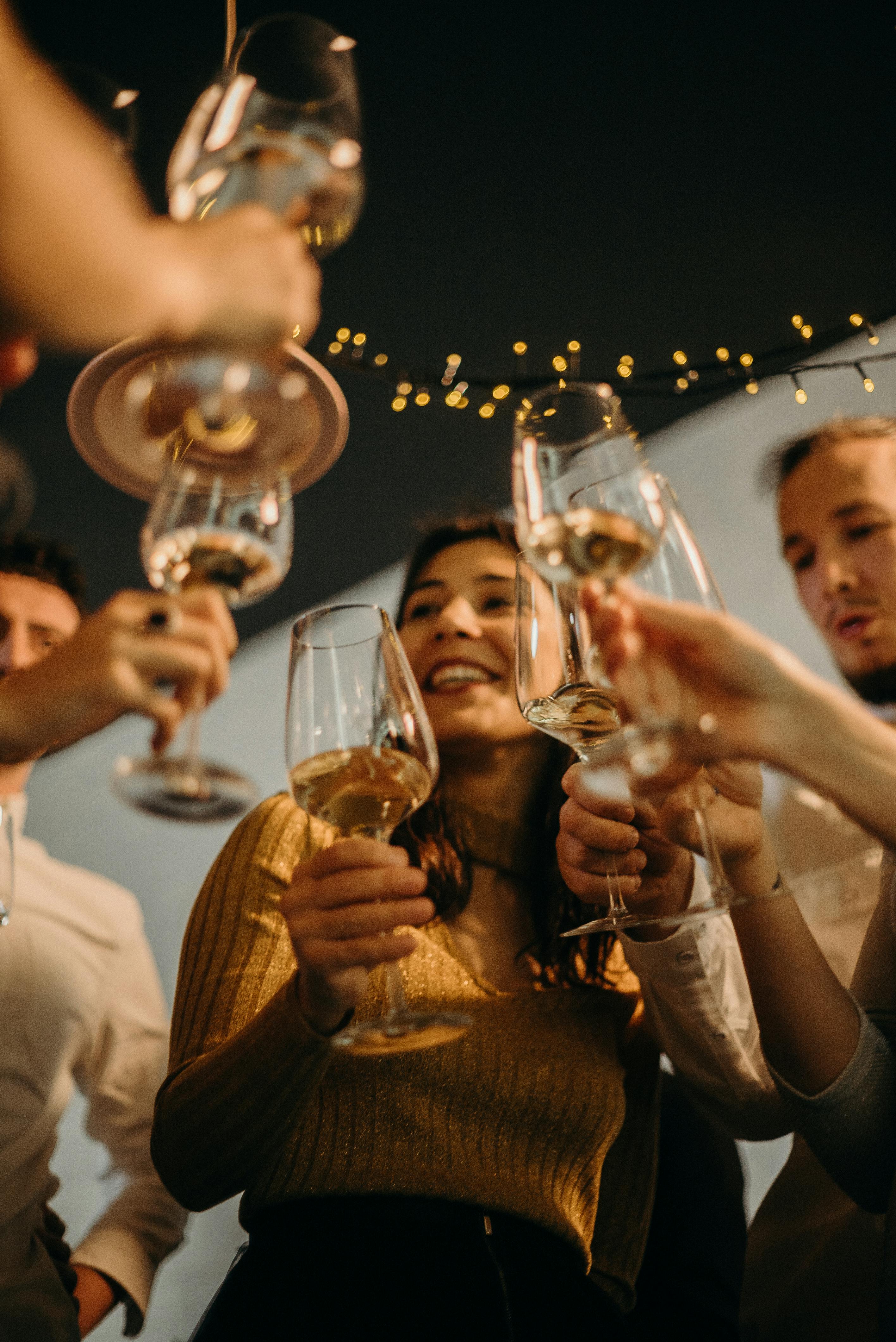 Menschen stoßen mit ihren Gläsern an | Quelle: Pexels