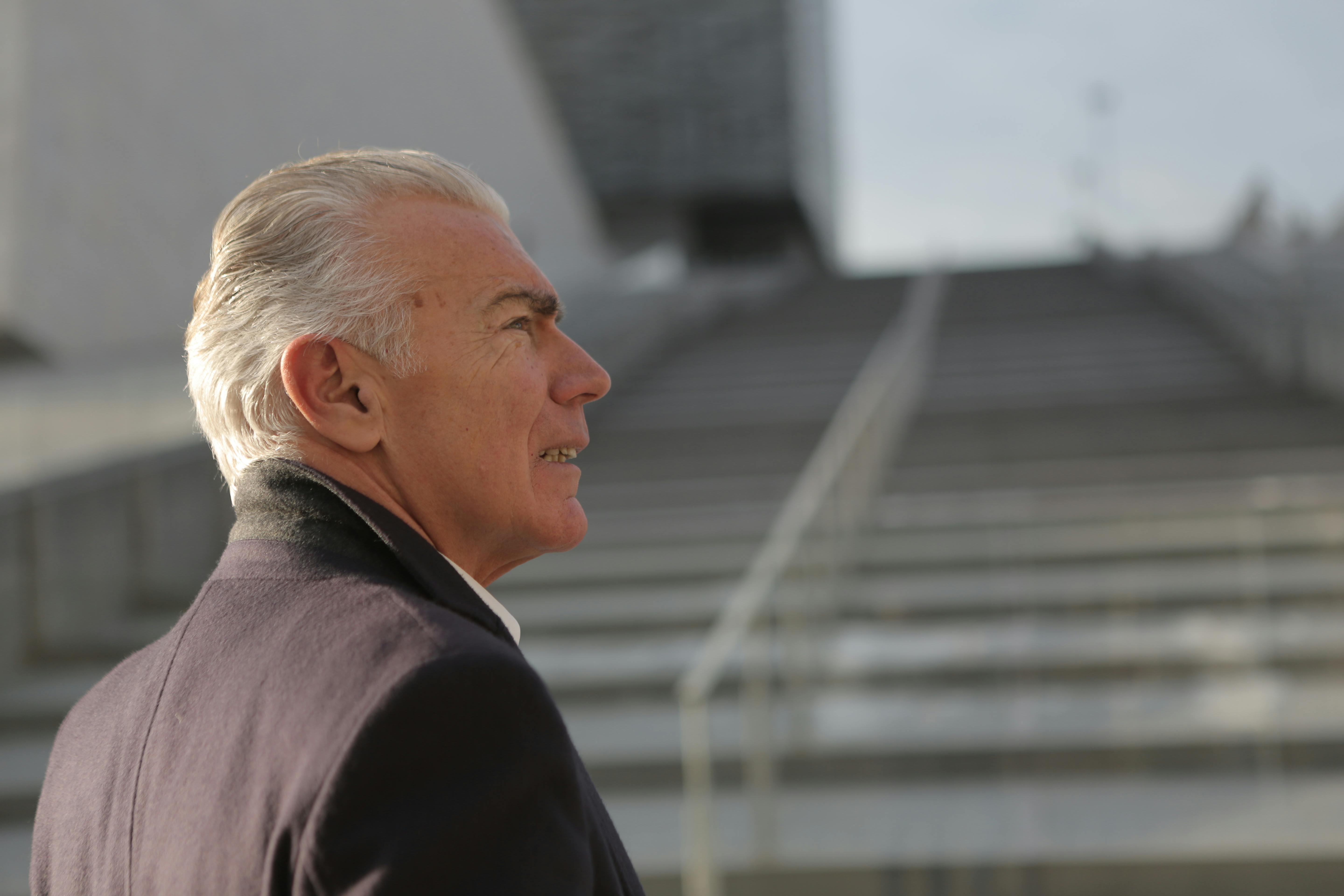 Älterer Mann, der neben einer Treppe steht | Quelle: Pexels