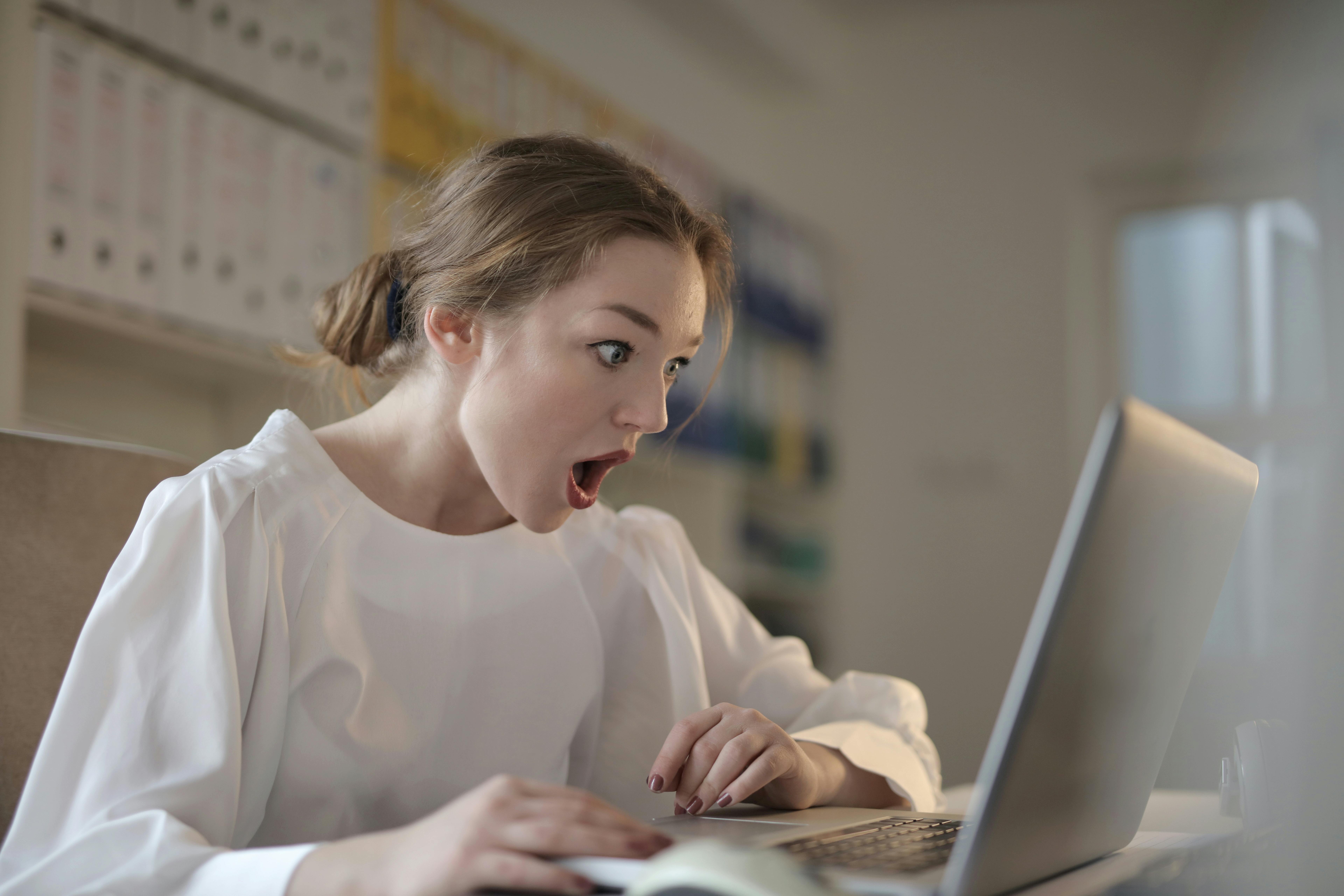 Eine schockierte Frau, die auf den Bildschirm eines Laptops schaut | Quelle: Pexels