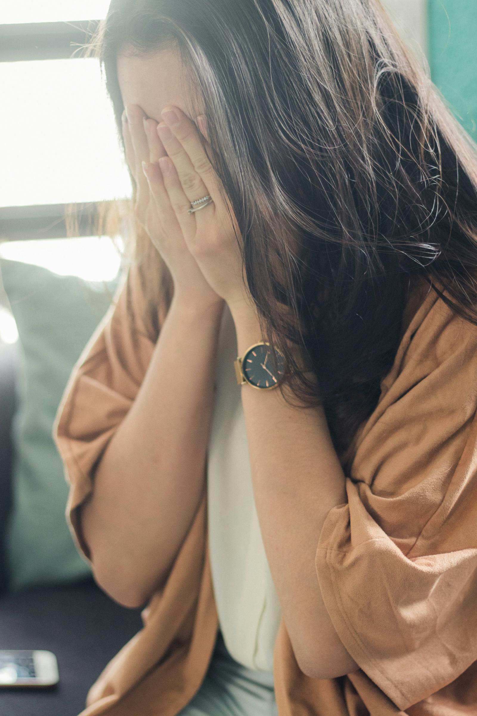 Eine Frau, die ihr Gesicht mit ihren Händen bedeckt | Quelle: Unsplash