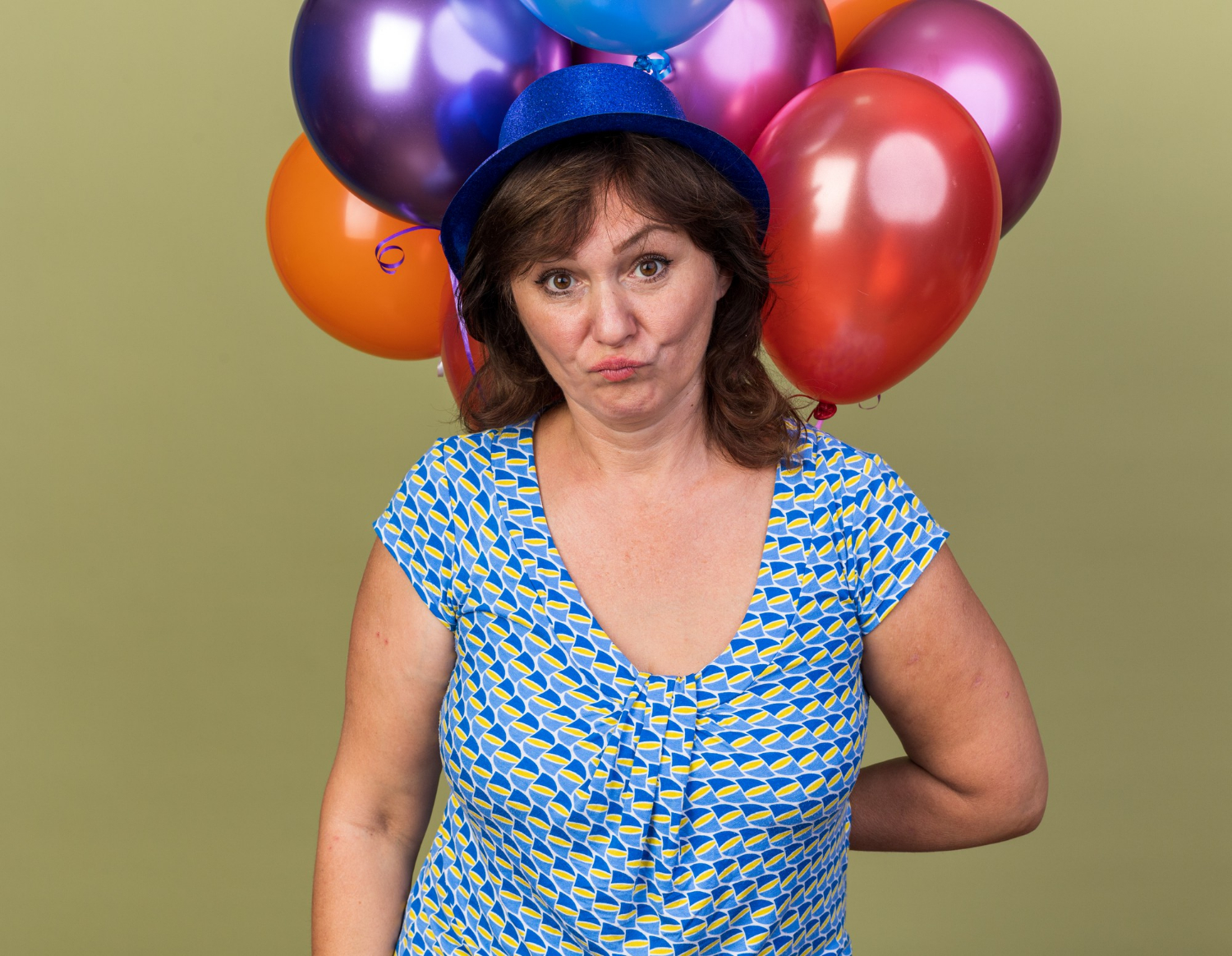 Eine fassungslose Frau mit bunten Luftballons | Quelle: Freepik