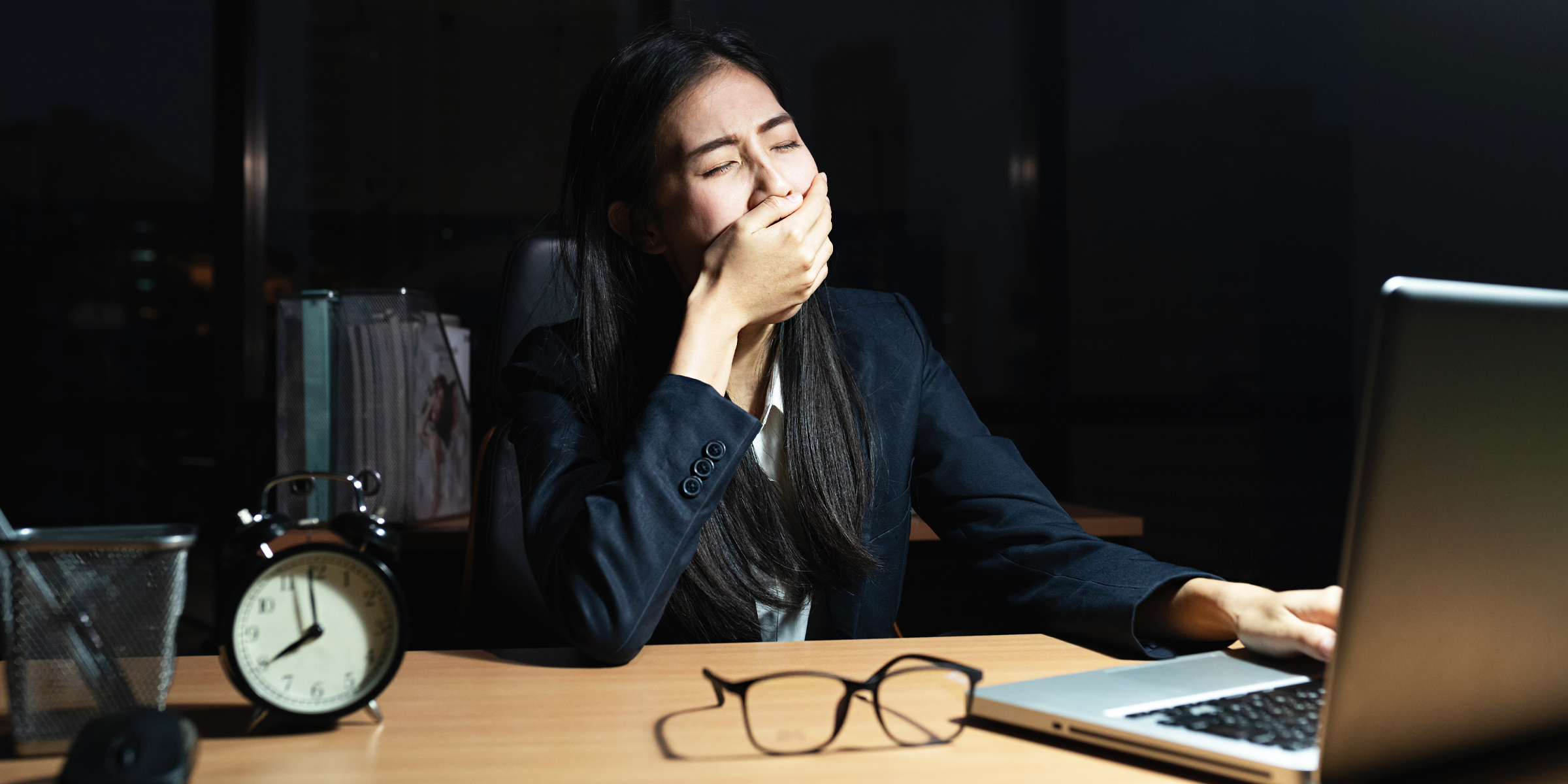 Erschöpfte Frau an einem Arbeitstisch | Quelle: Shutterstock