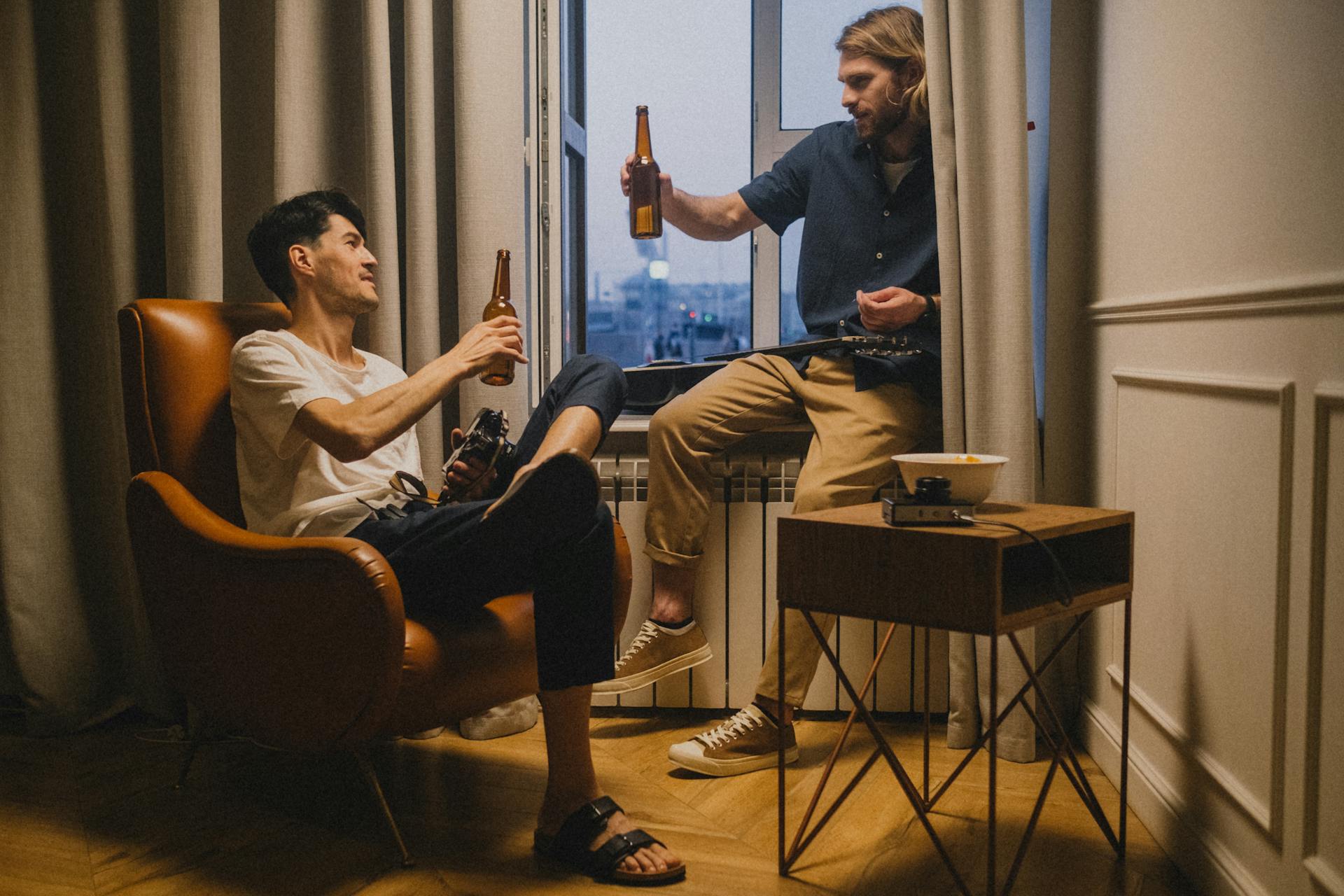 Zwei Männer stoßen mit ihren Bierflaschen an | Quelle: Pexels