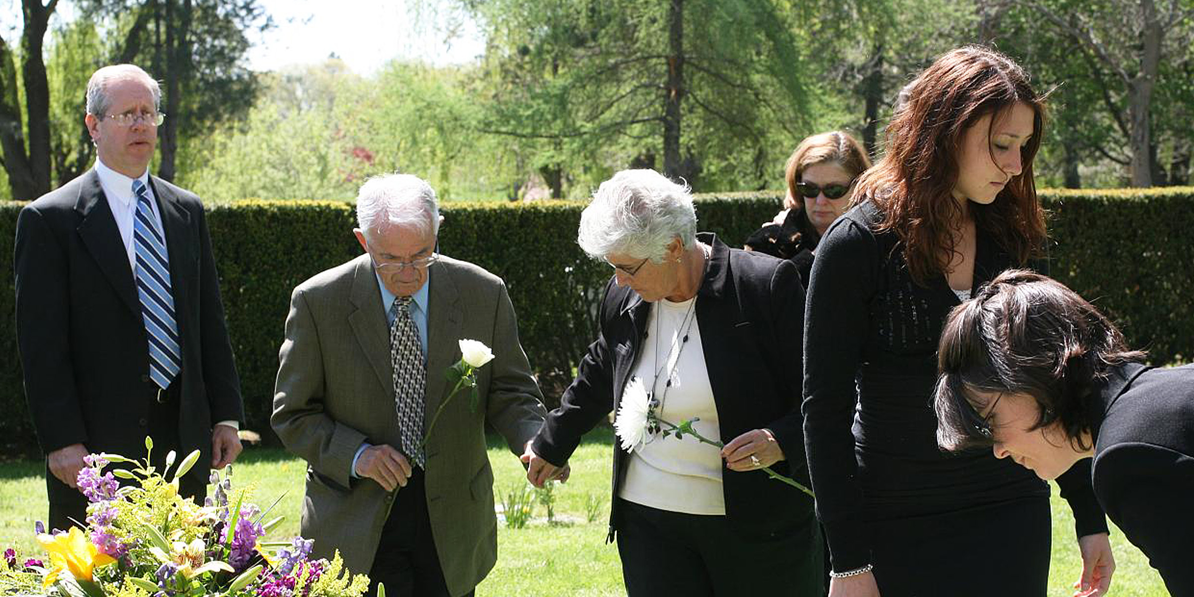 Menschen stehen in der Nähe eines Grabes | Quelle: Flickr