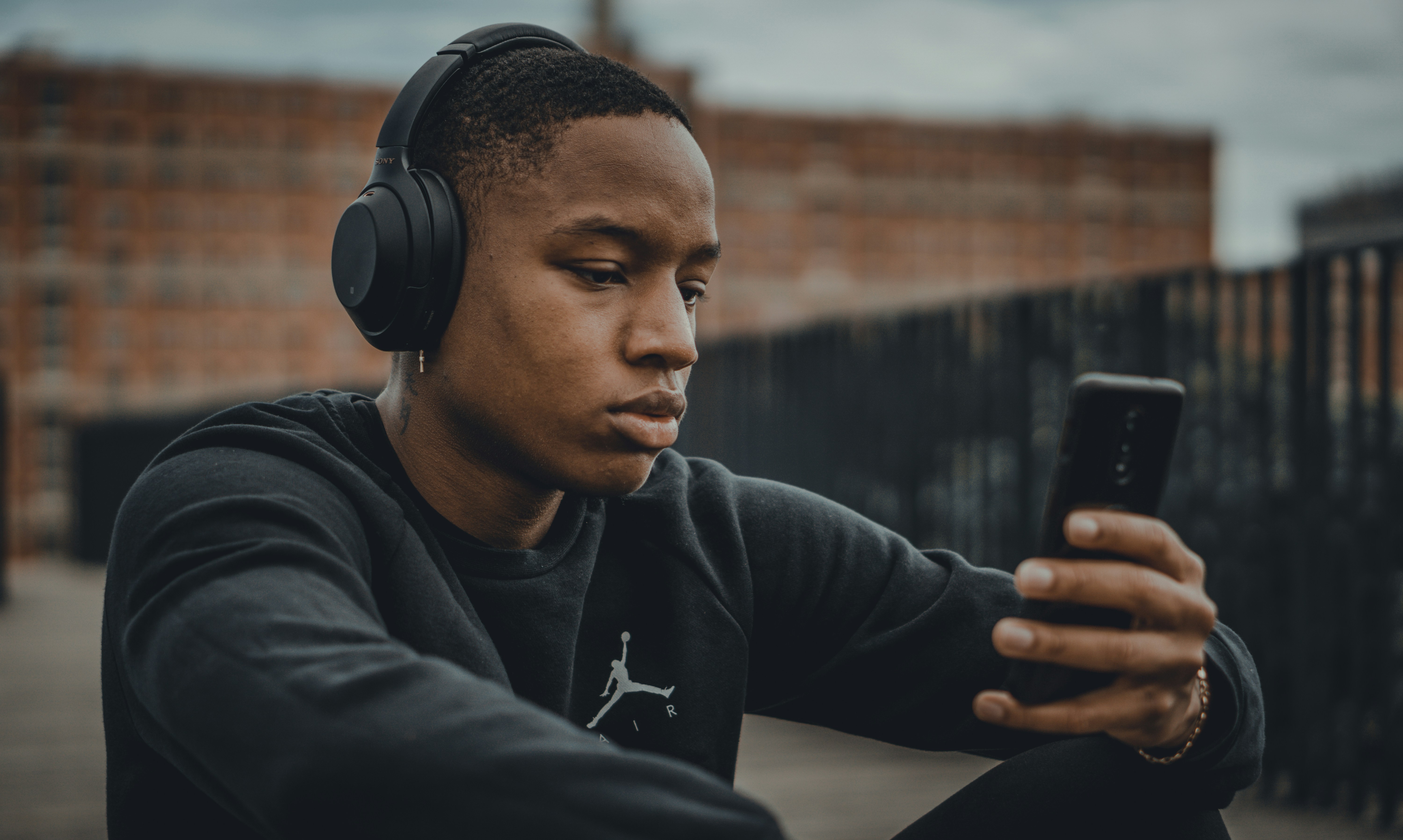 Ein unglücklicher Junge, der sein Telefon benutzt | Quelle: Unsplash