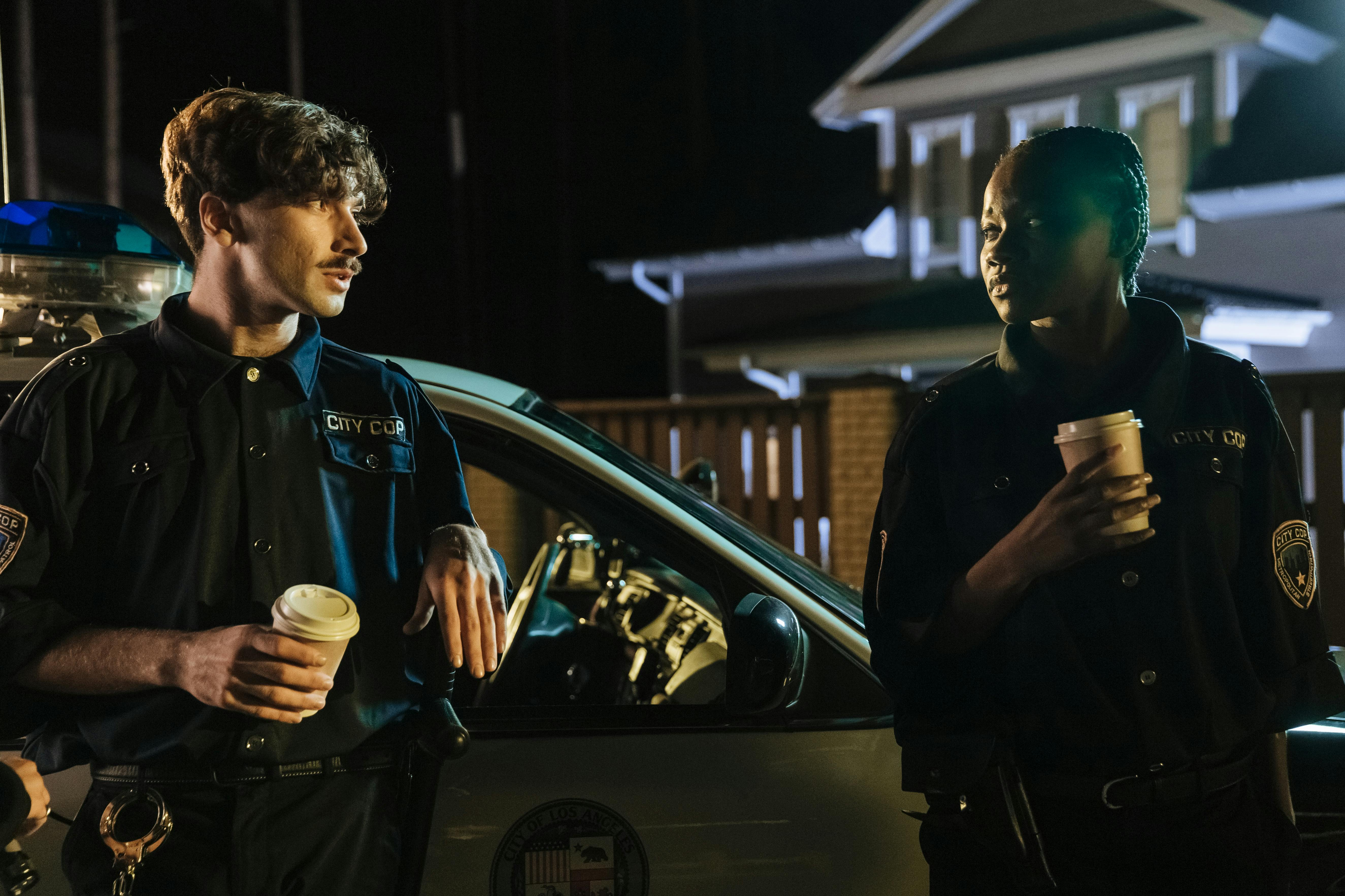 Polizisten, die neben einem Streifenwagen stehen | Quelle: Pexels