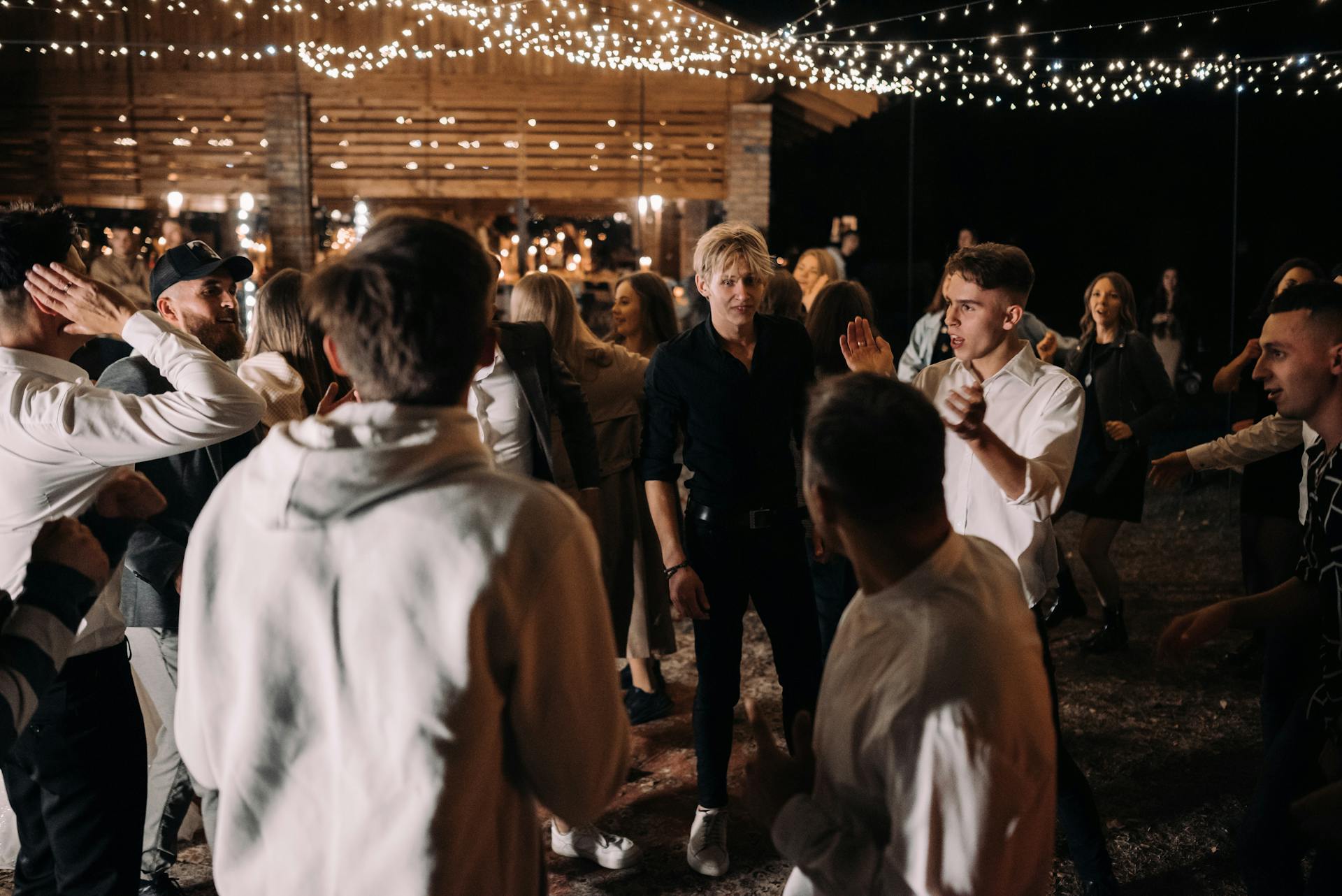 Eine Gruppe von Menschen tanzt auf einer Party mit Lichterketten | Quelle: Pexels