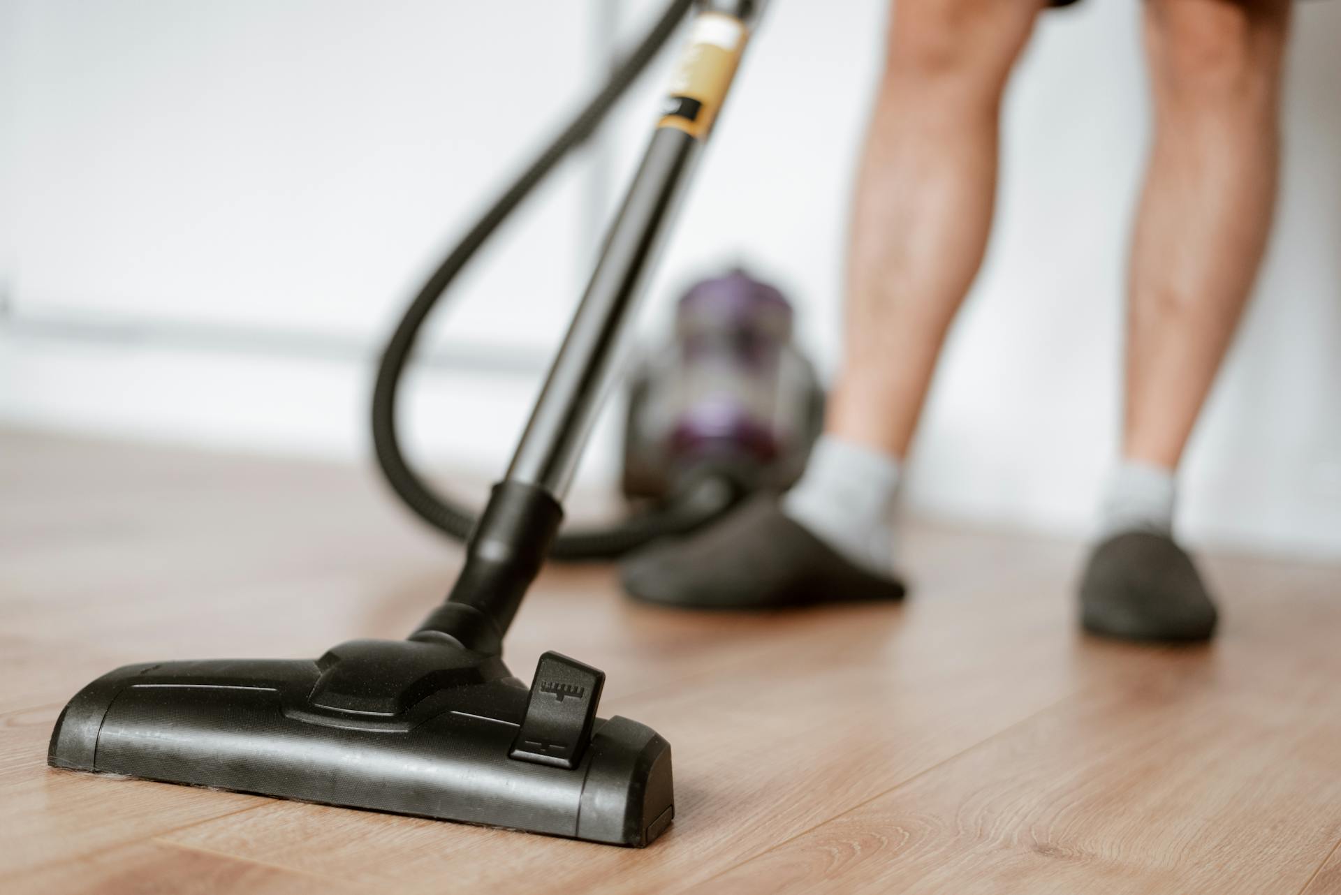 Ein Mann beim Staubsaugen des Bodens | Quelle: Pexels