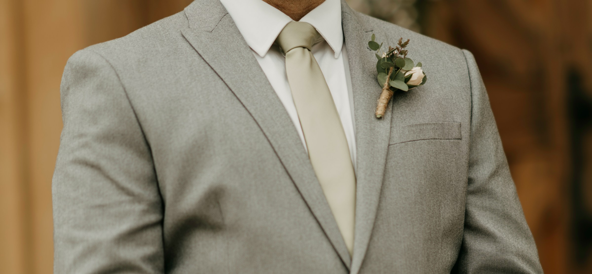 Ein Mann in einem grauen Anzug mit einer Boutonniere am Revers | Quelle: Unsplash
