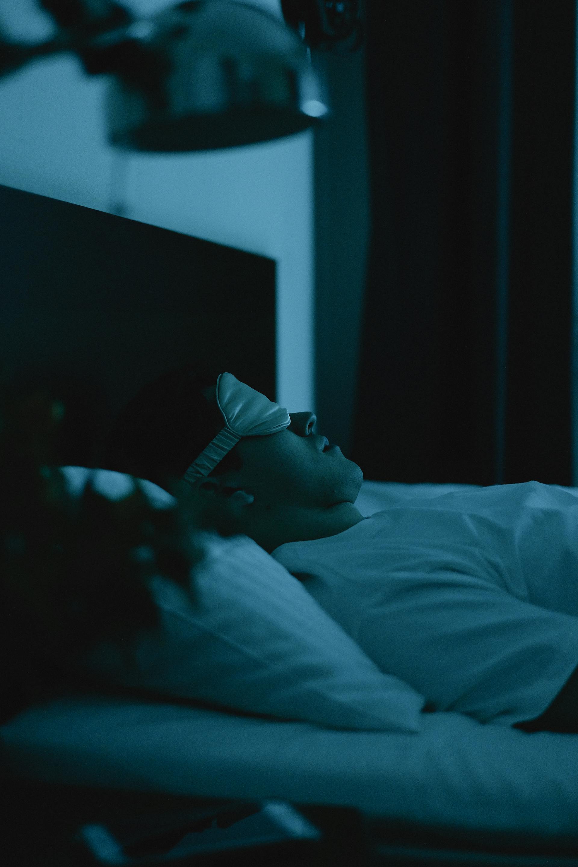 Ein Mann trägt eine Schlafmaske, während er im Bett liegt | Quelle: Pexels