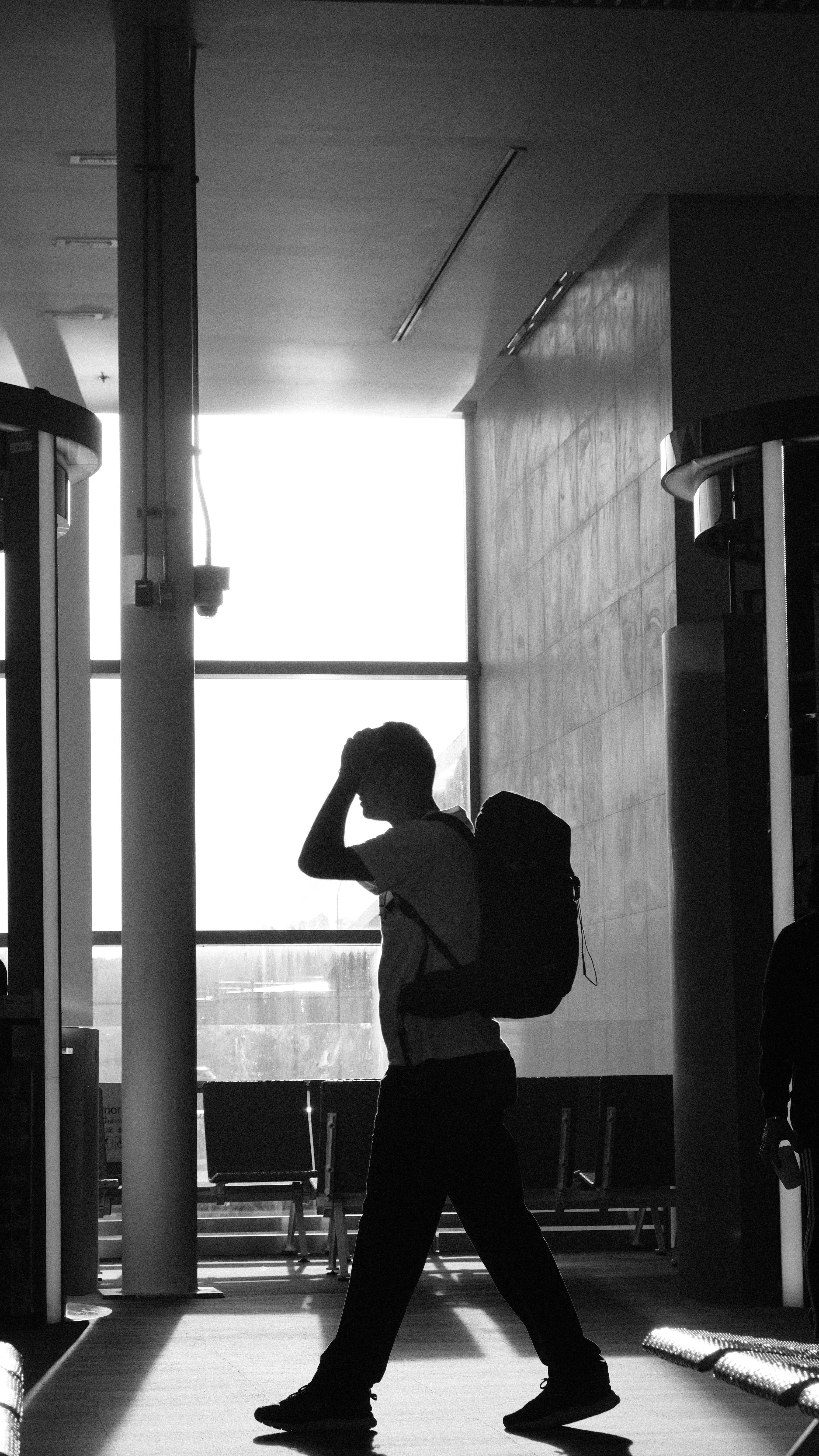 Mann mit Rucksack auf einem Flughafen | Quelle: Pexels