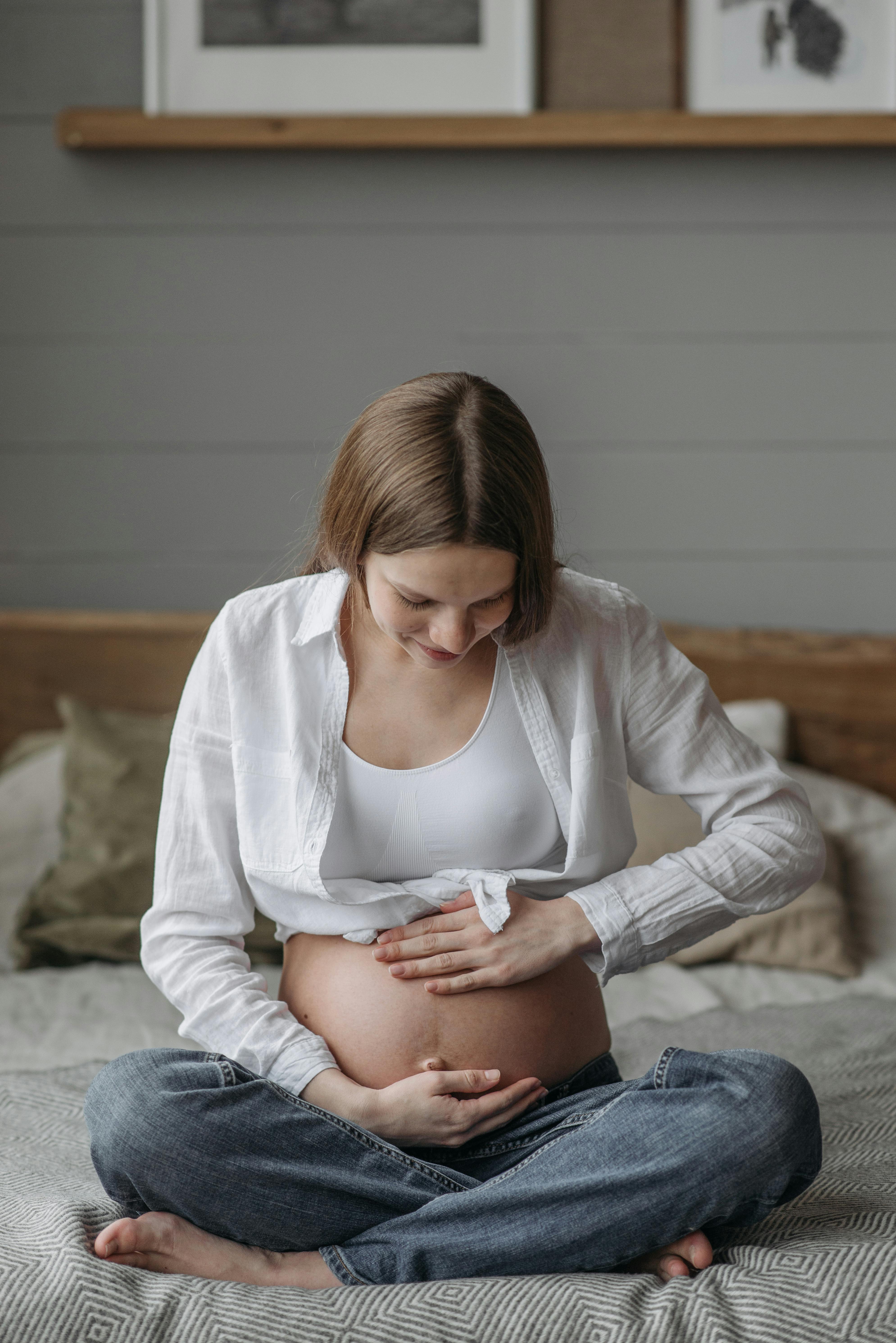 Eine schwangere Frau, die ihren Babybauch wiegt | Quelle: Pexels