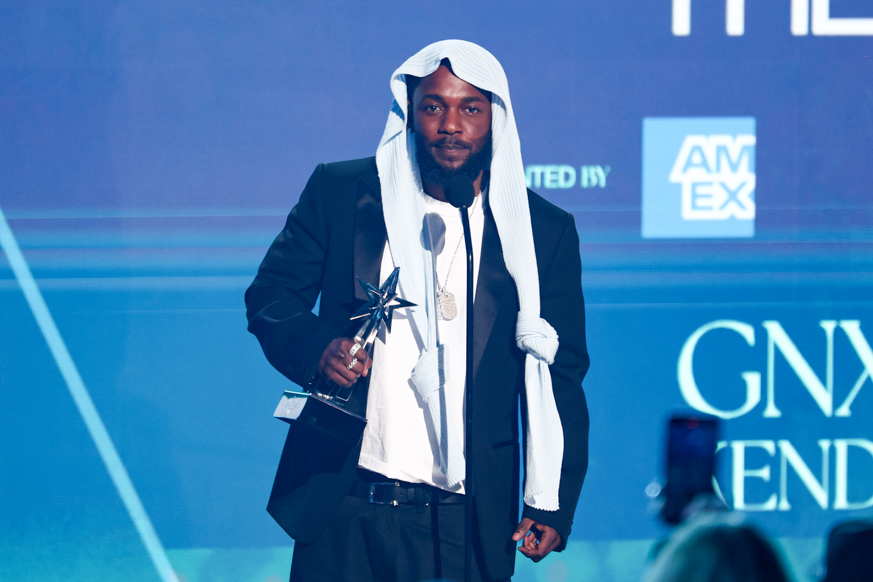 Kendrick Lamar nimmt einen seiner fünf BET Awards entgegen, während er einen schwarzen Anzug und eine Kopfbedeckung trägt, die im Internet für Aufsehen sorgte. Der Moment fand auf der Bühne des Peacock Theaters während der BET Awards 2025 in Los Angeles, Kalifornien, statt.