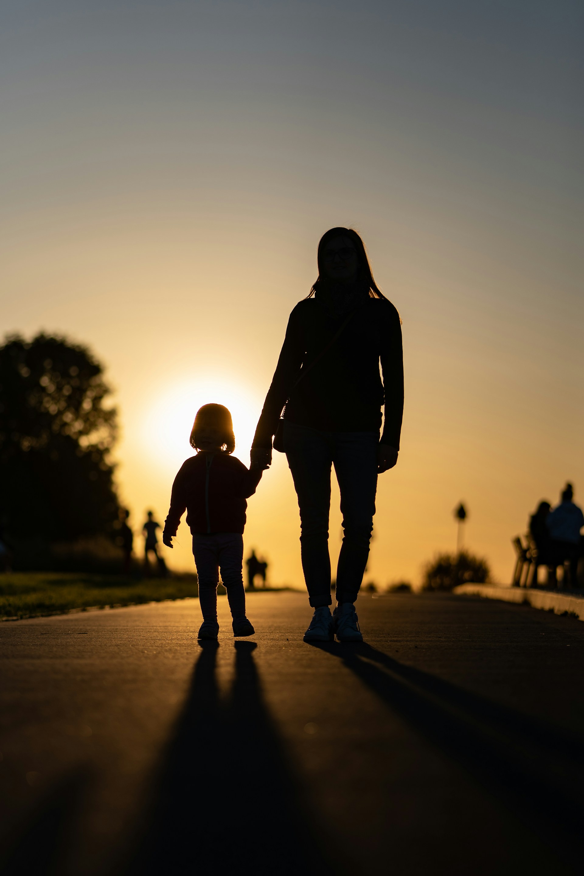 Eine Mutter und ihre kleine Tochter beobachten den Sonnenuntergang | Quelle: Unsplash