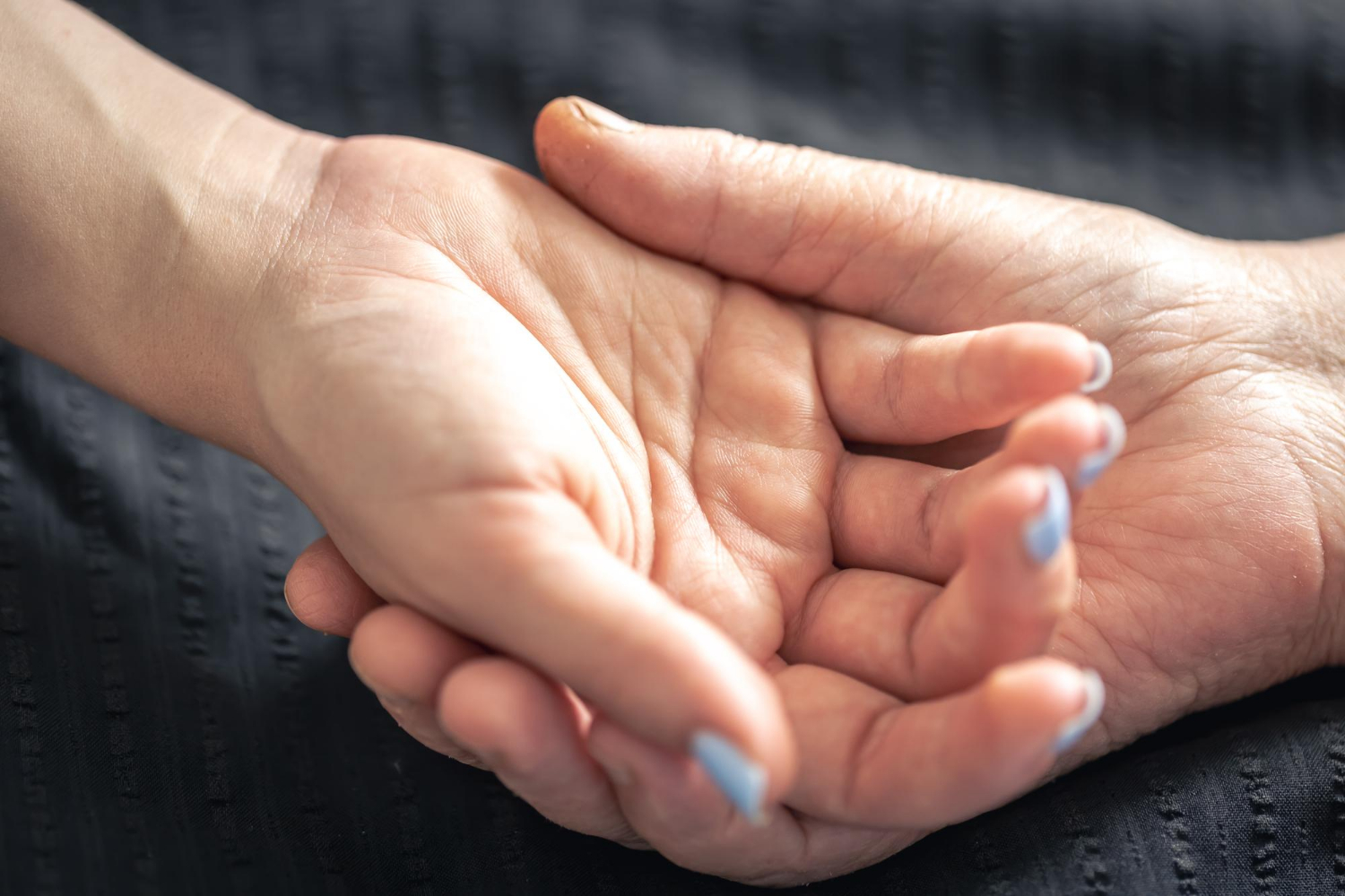 Eine ältere Person hält die Hand einer jungen Frau | Quelle: Freepik