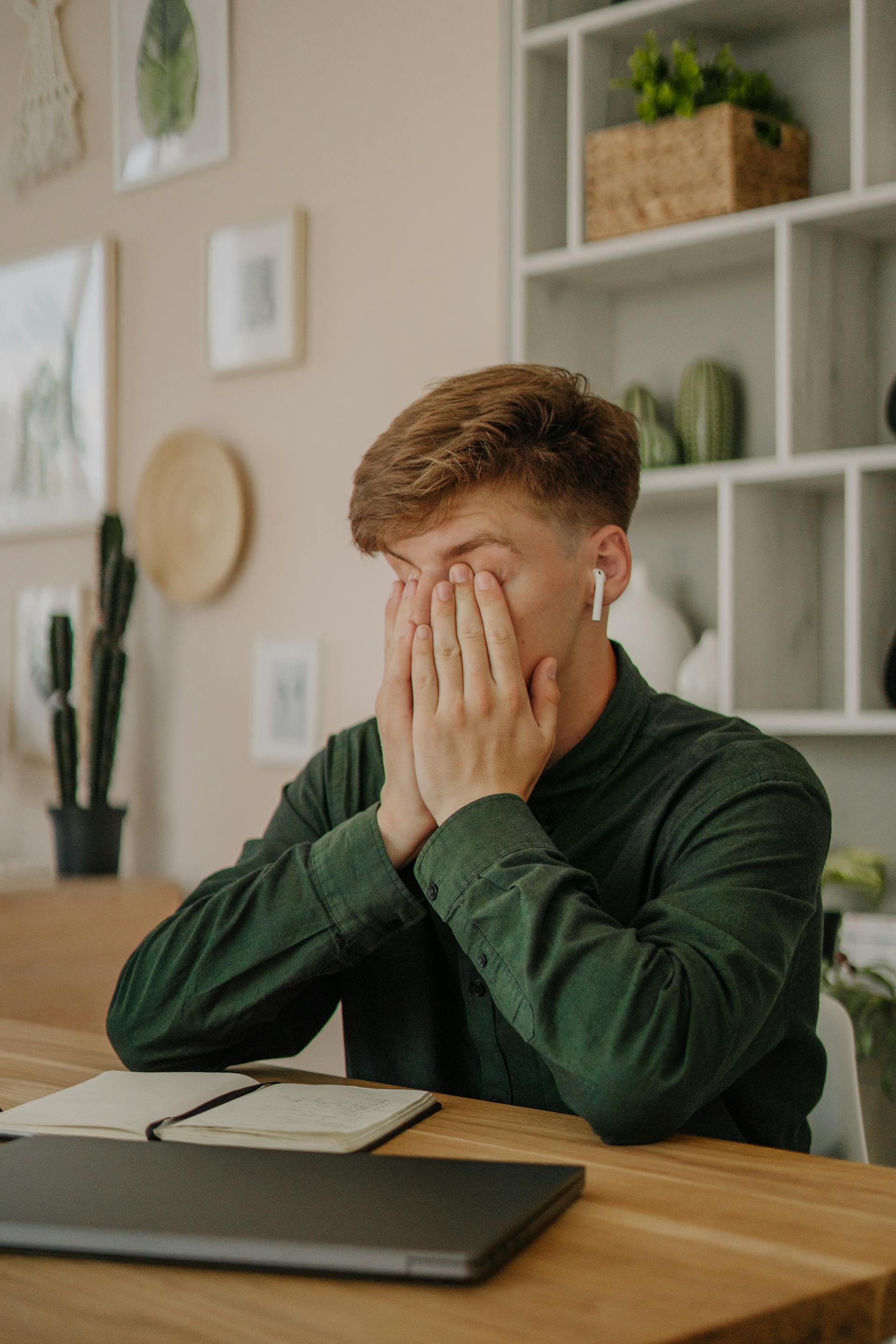 Ein junger Mann, der sein Gesicht bedeckt | Quelle: Pexels