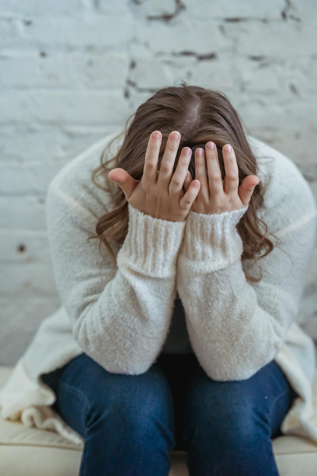 Eine traurige Frau, die auf der Couch sitzt | Quelle: Pexels