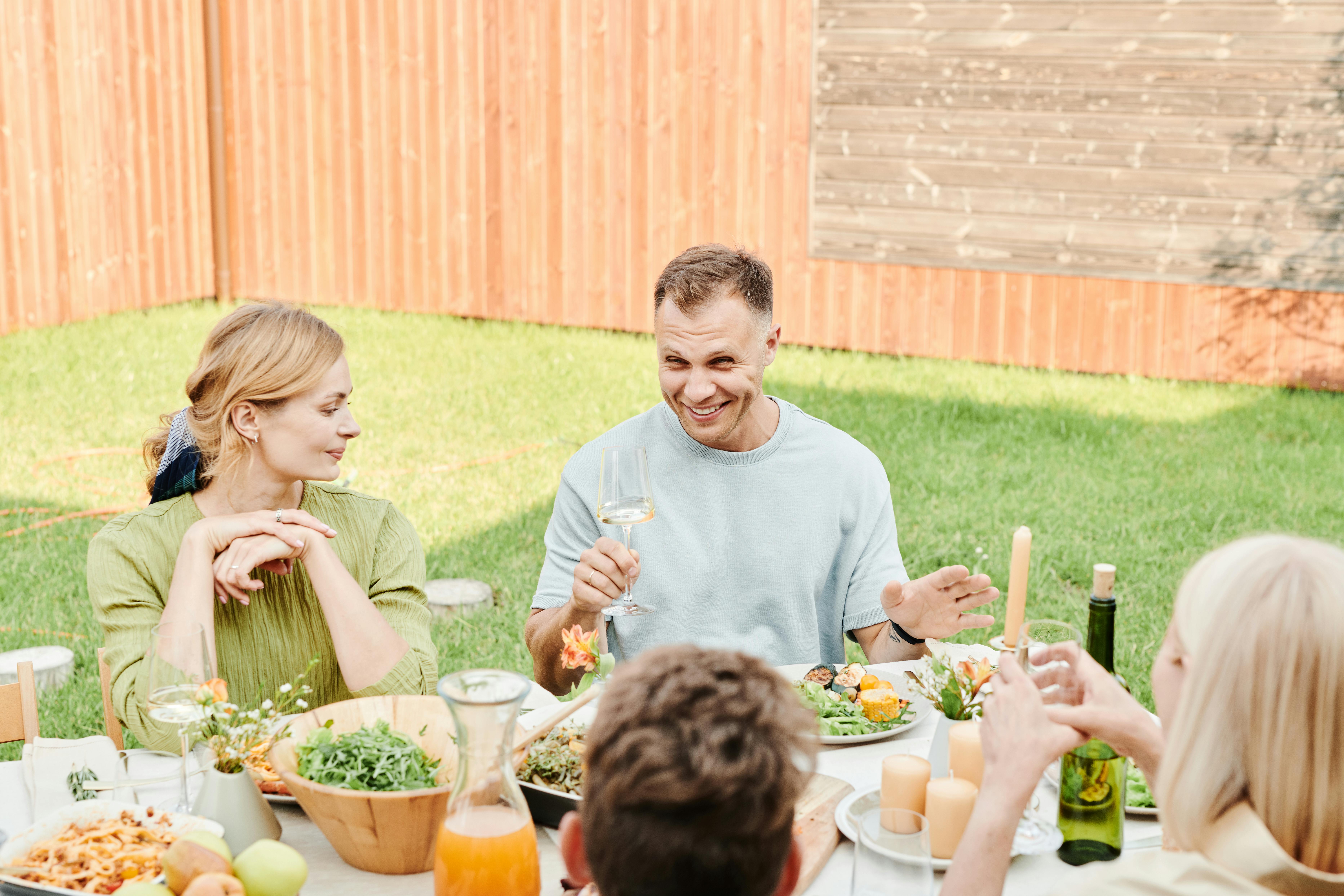 Eine Familie beim Essen im Hinterhof | Quelle: Pexels