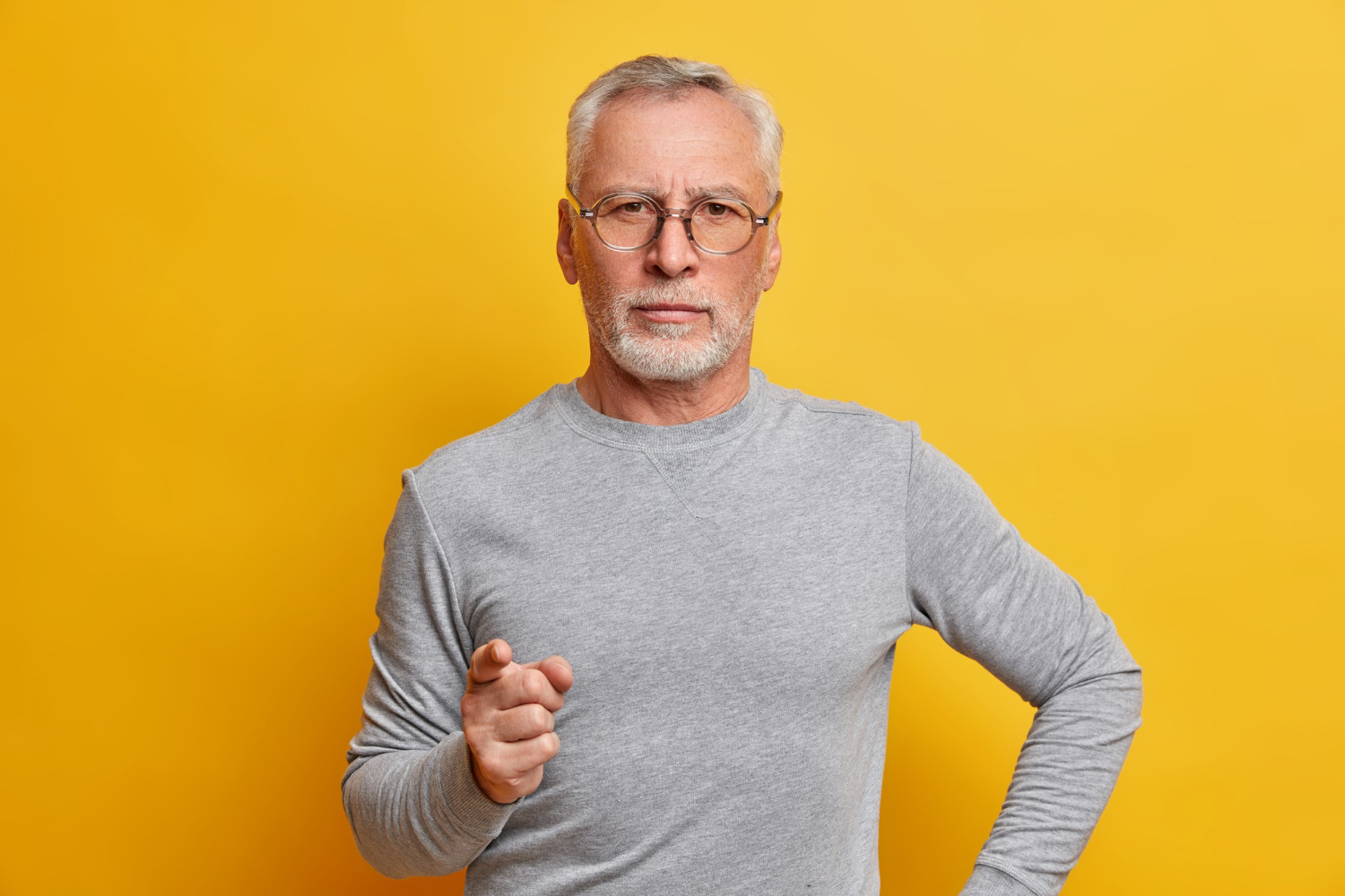 Ein strenger älterer Mann, der warnend mit dem Finger zeigt | Quelle: Freepik
