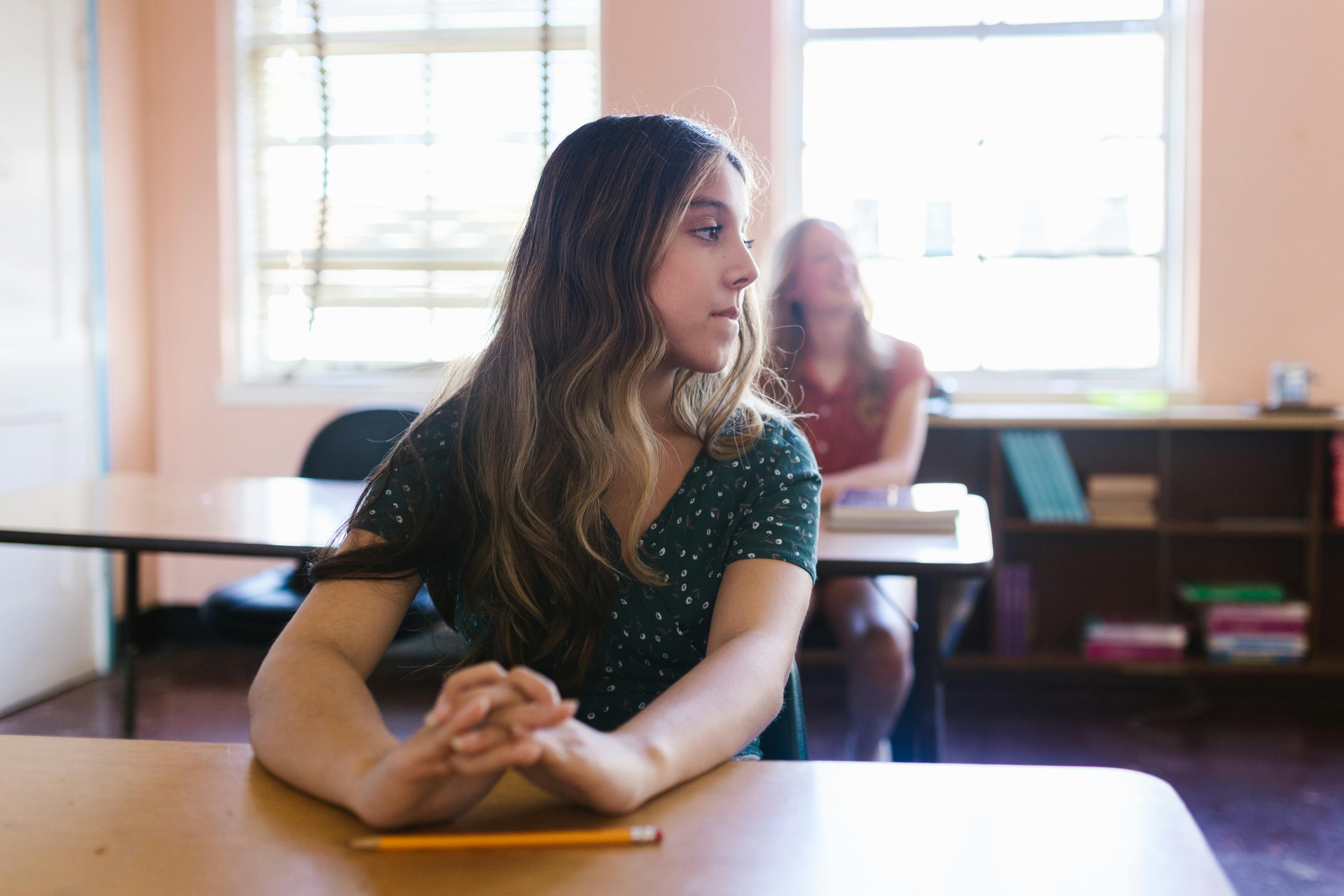 Ein Mädchen im Teenageralter sitzt in einem Klassenzimmer | Quelle: Pexels