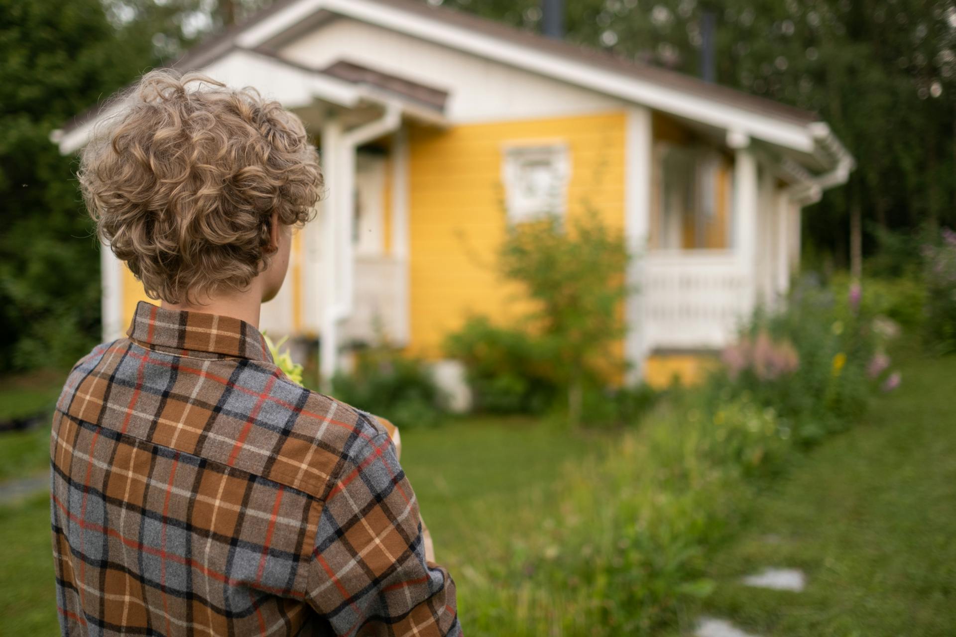 Ein Jugendlicher betrachtet ein Haus | Quelle: Pexels
