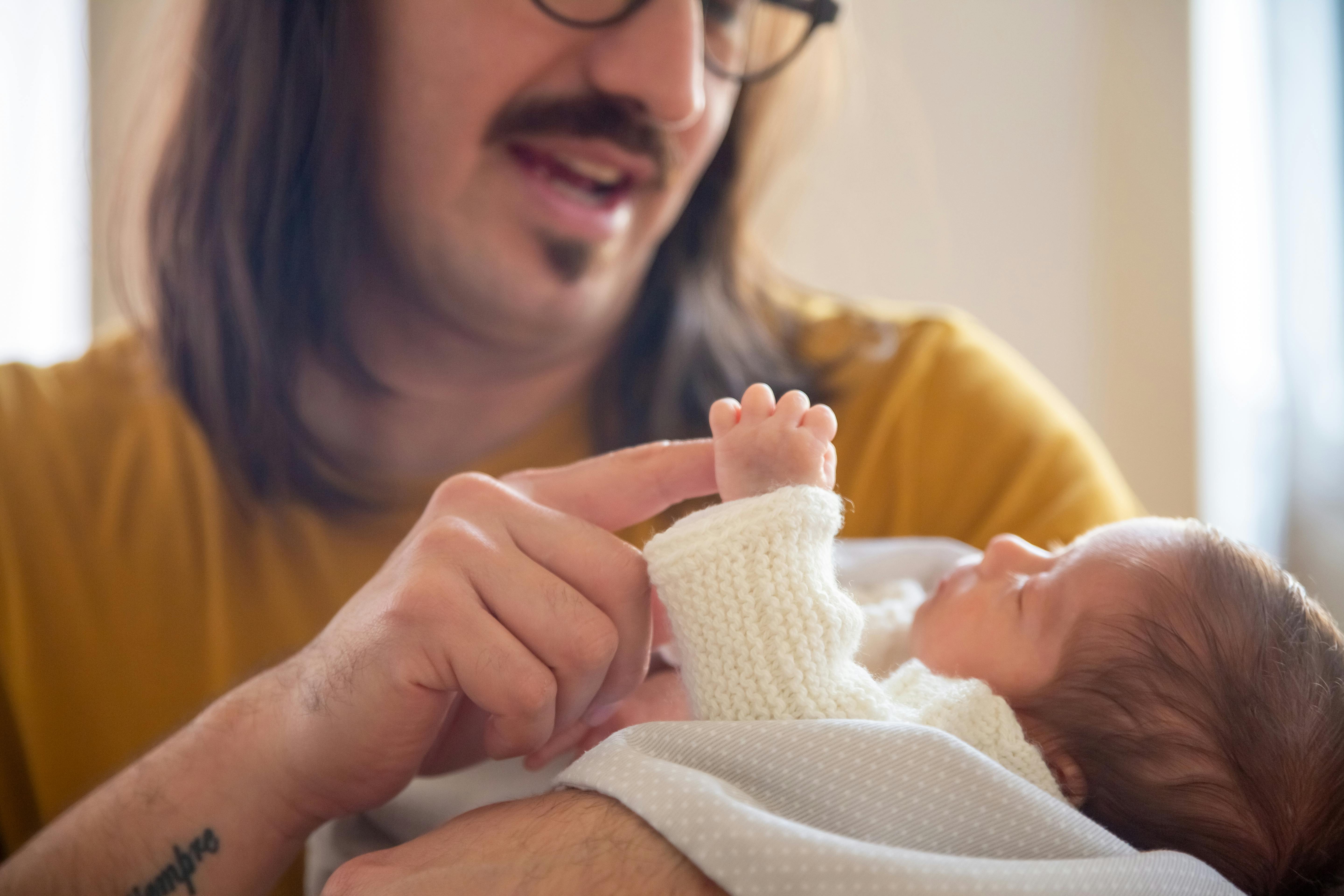 Ein Mann spielt mit einem Baby | Quelle: Pexels