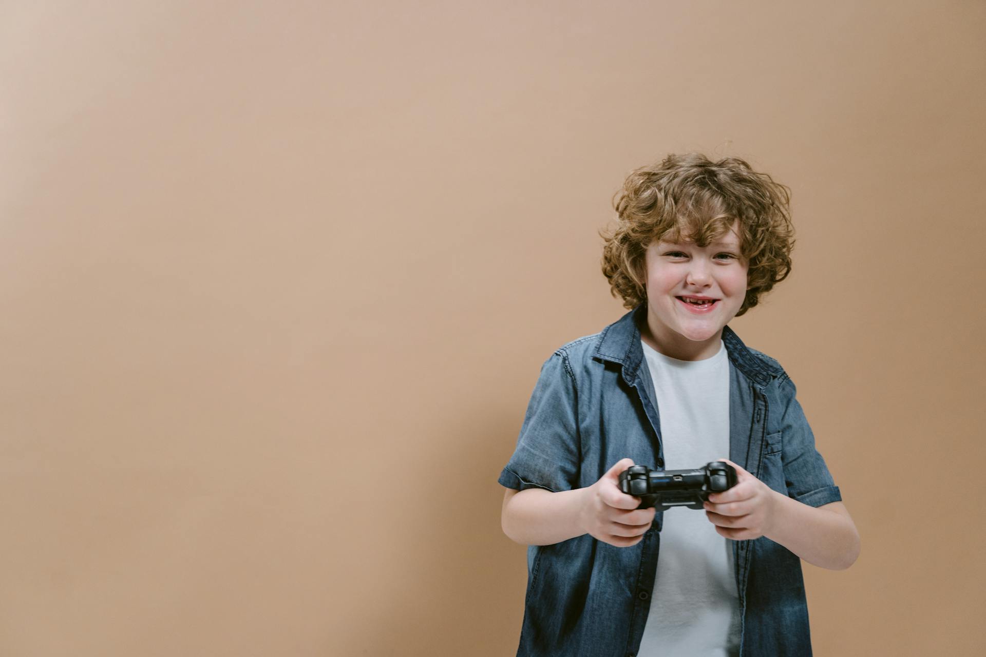 Ein glücklicher Teenager, der einen Controller hält | Quelle: Pexels