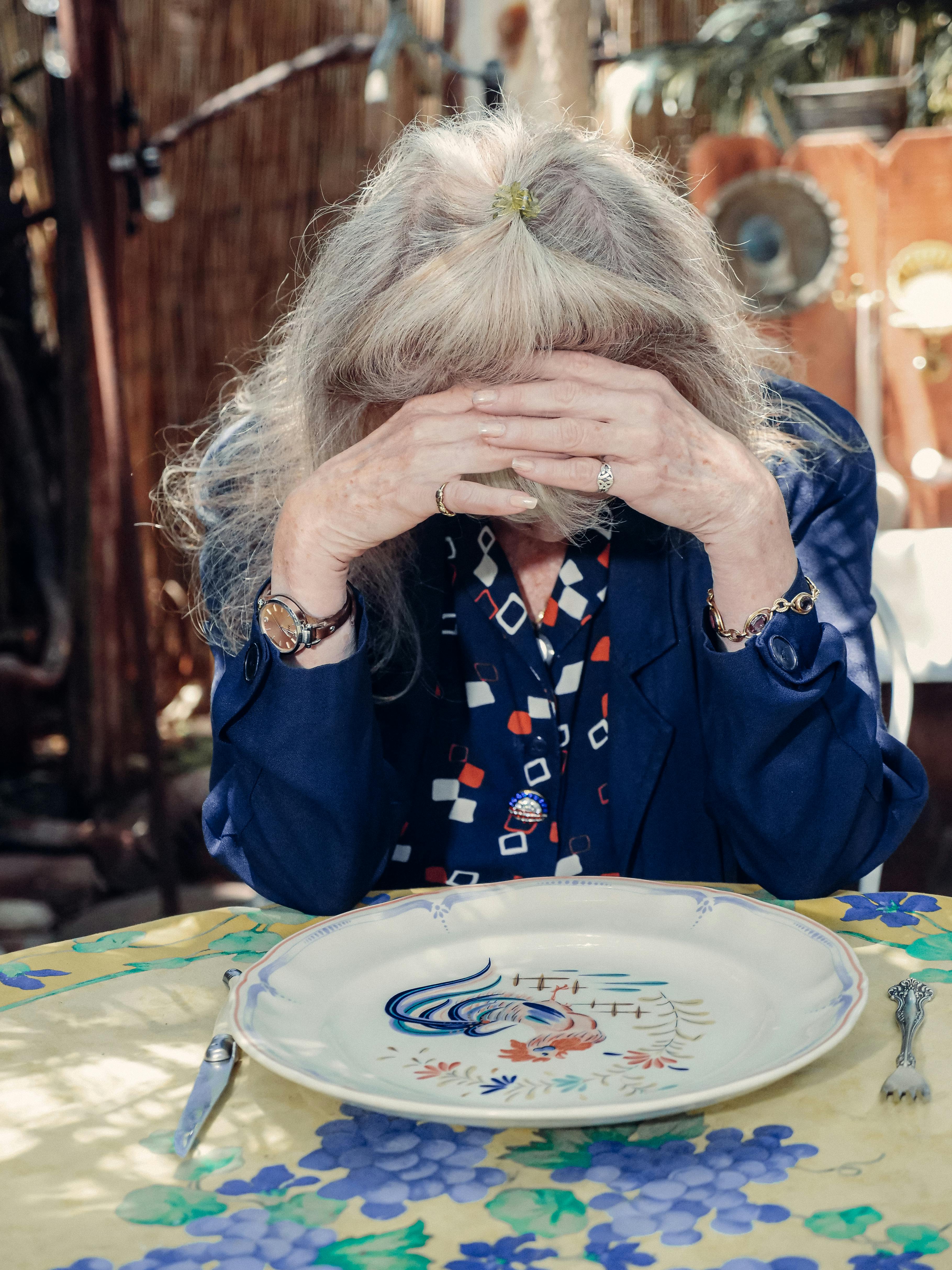 Ältere Frau, die ihr Gesicht bedeckt | Quelle: Pexels