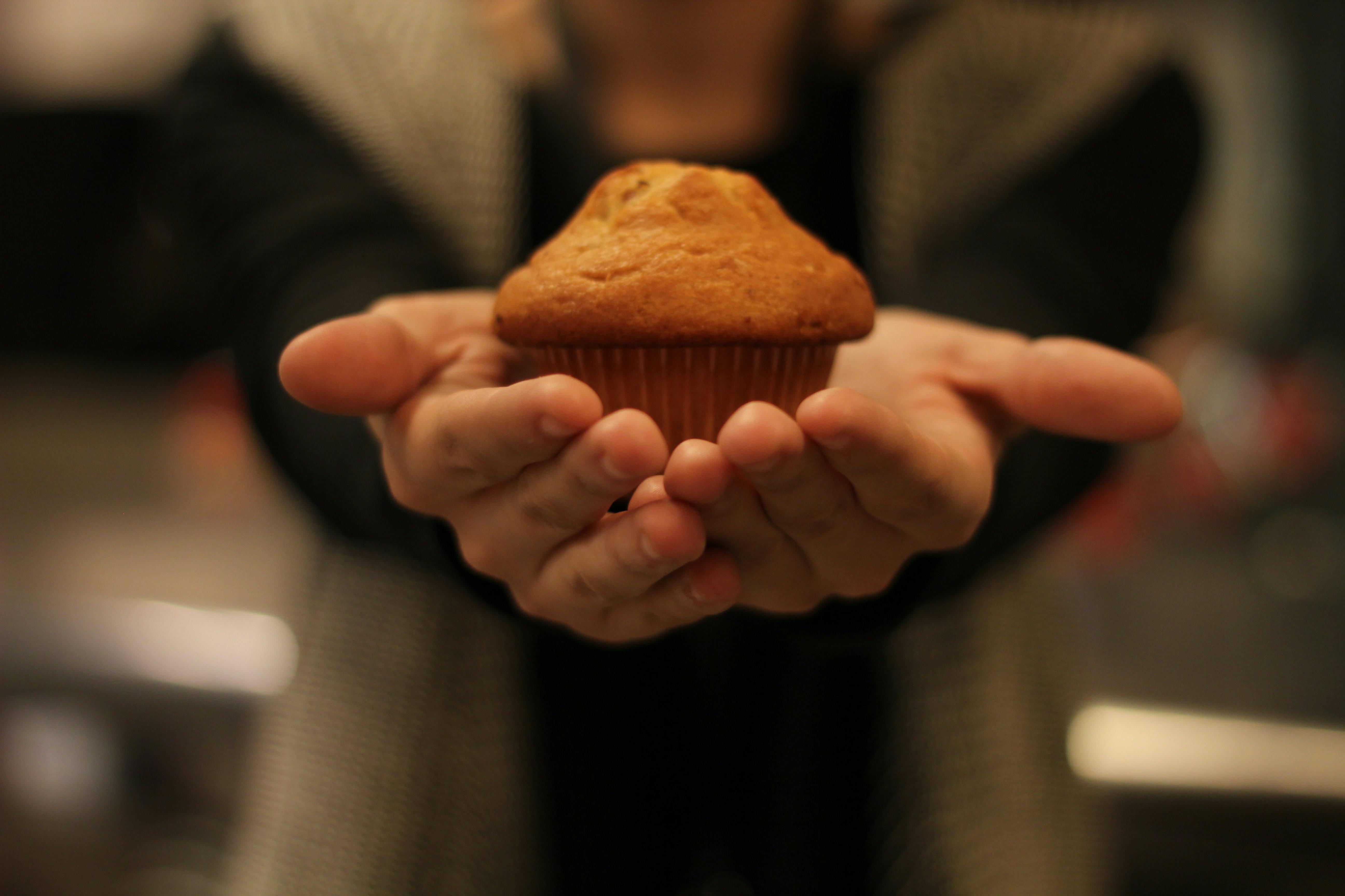 Ein Mann präsentiert einen Muffin | Quelle: Pexels