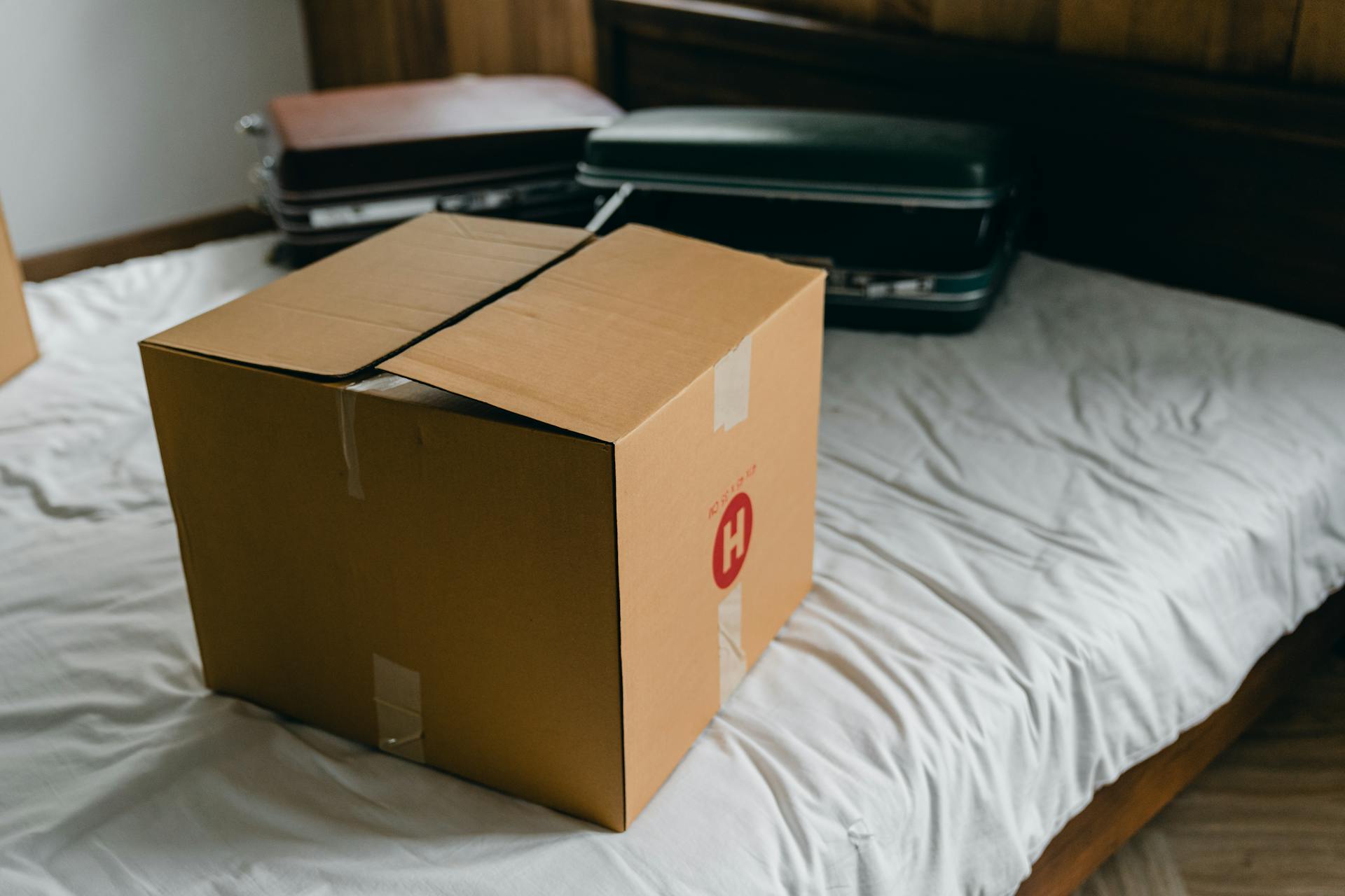 Kisten und Koffer auf einem Bett | Quelle: Pexels