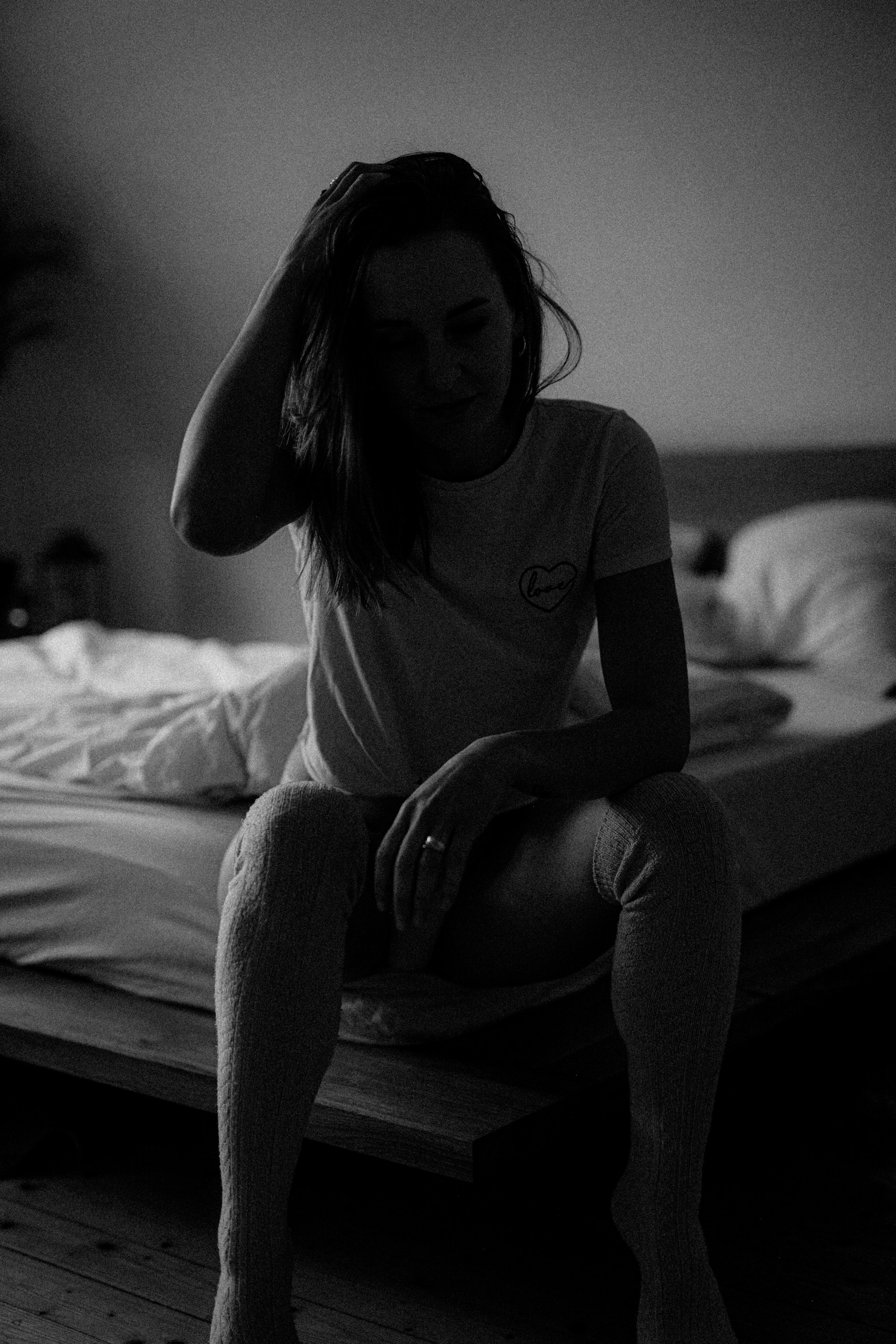 Eine Frau, die auf der Kante eines Bettes sitzt | Quelle: Unsplash