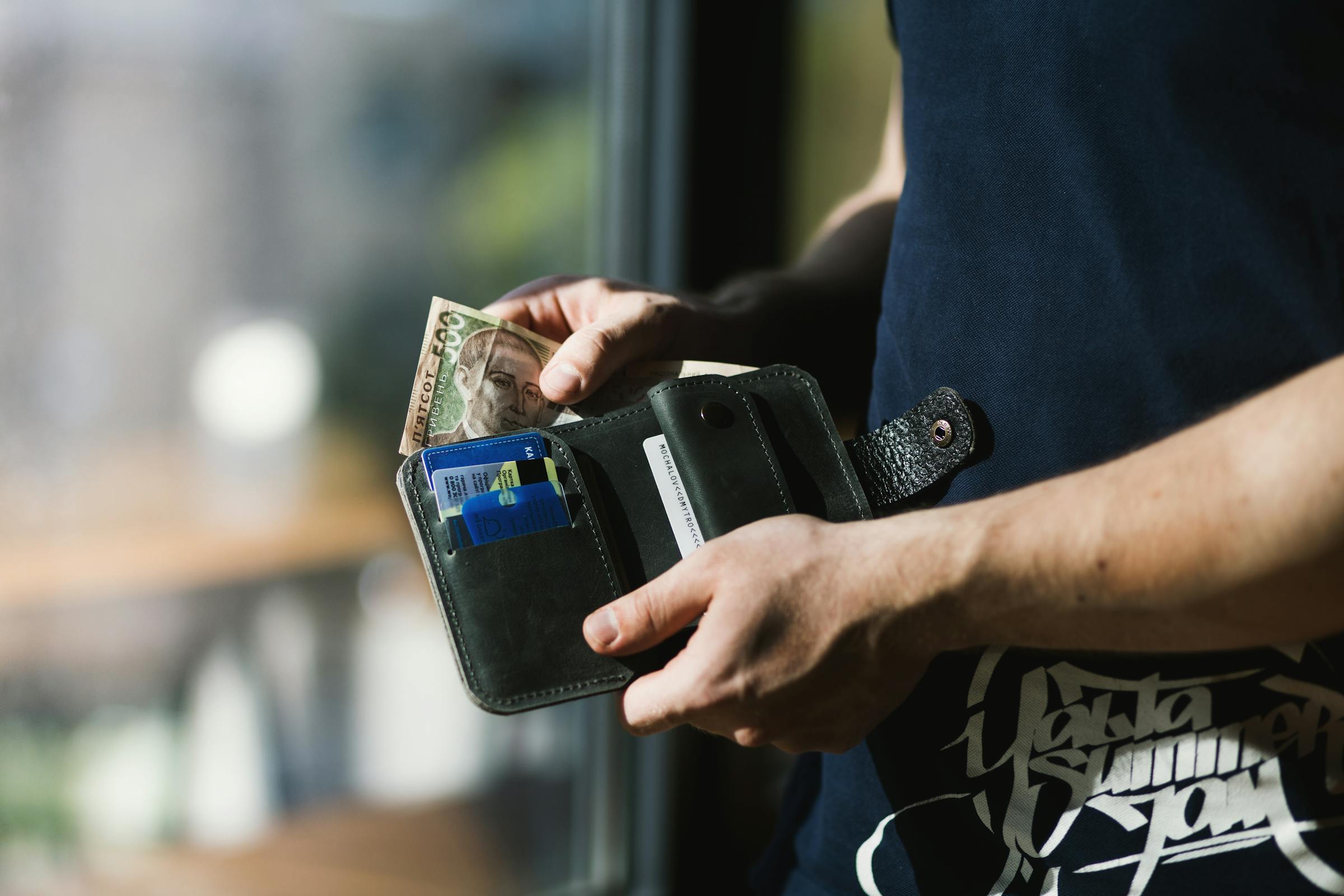 Ein Mann holt Bargeld aus seiner Brieftasche | Quelle: Pexels