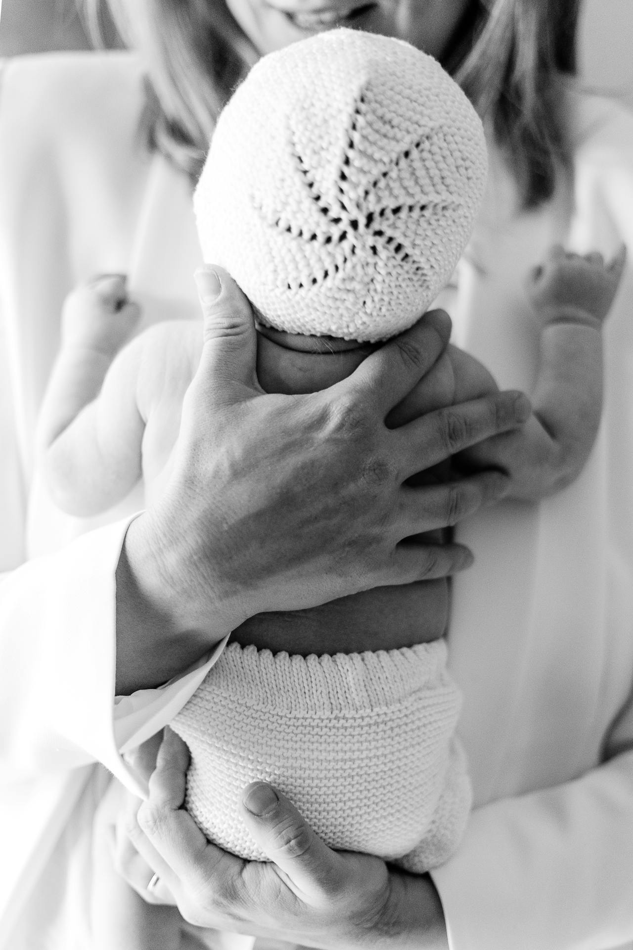 Graustufenaufnahme einer Mutter, die ihr neugeborenes Baby im Arm hält | Quelle: Pexels
