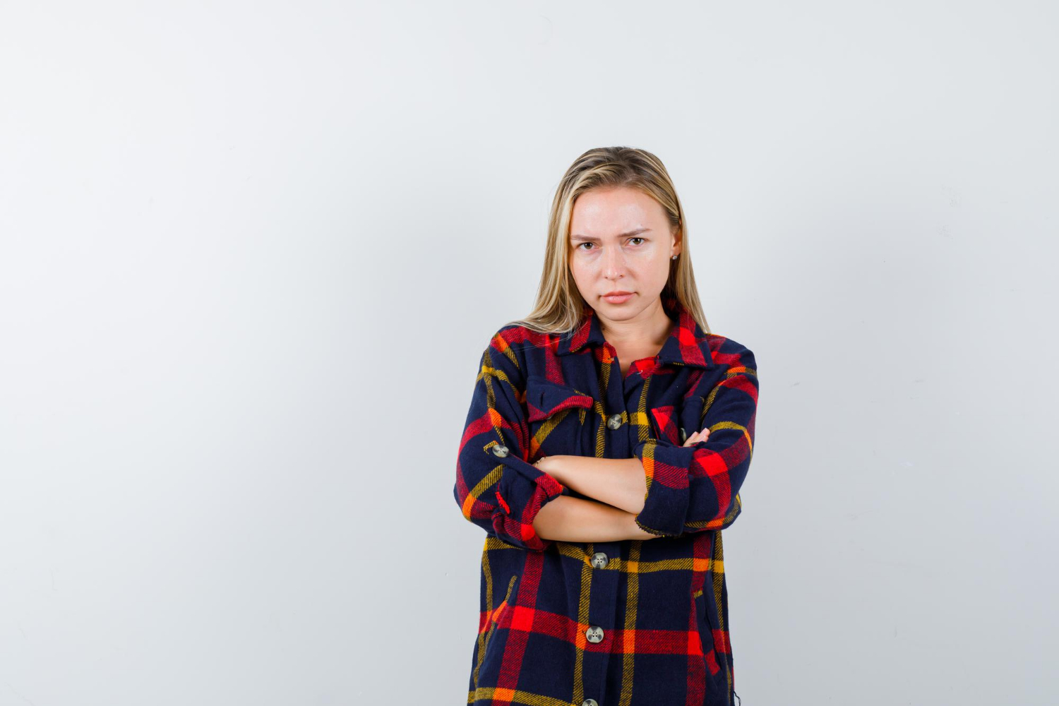 Eine verärgerte junge Frau mit verschränkten Armen | Quelle: Freepik