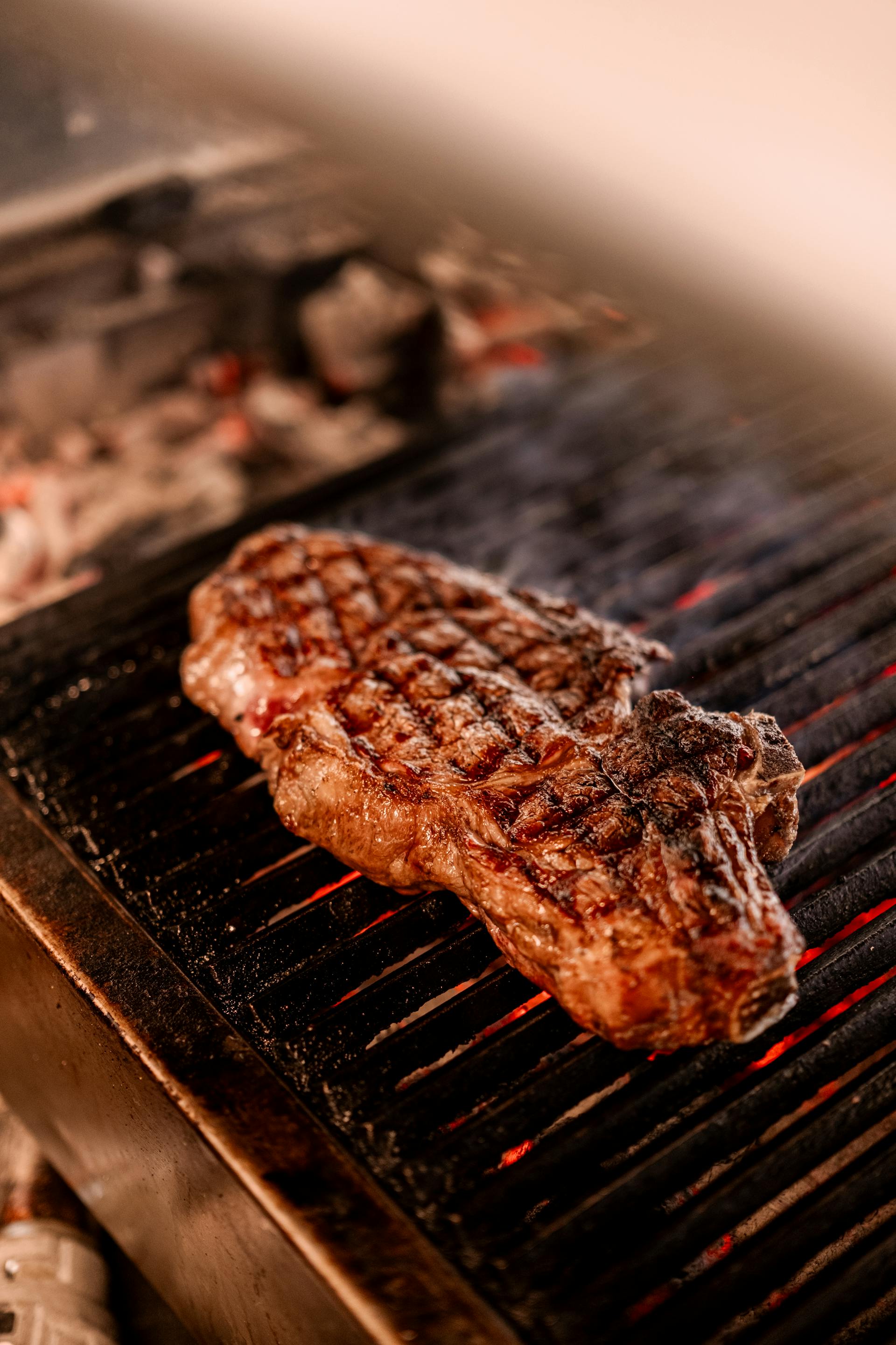 Ein Stück gegrilltes Steak auf einem Grill mit offener Flamme | Quelle: Pexels