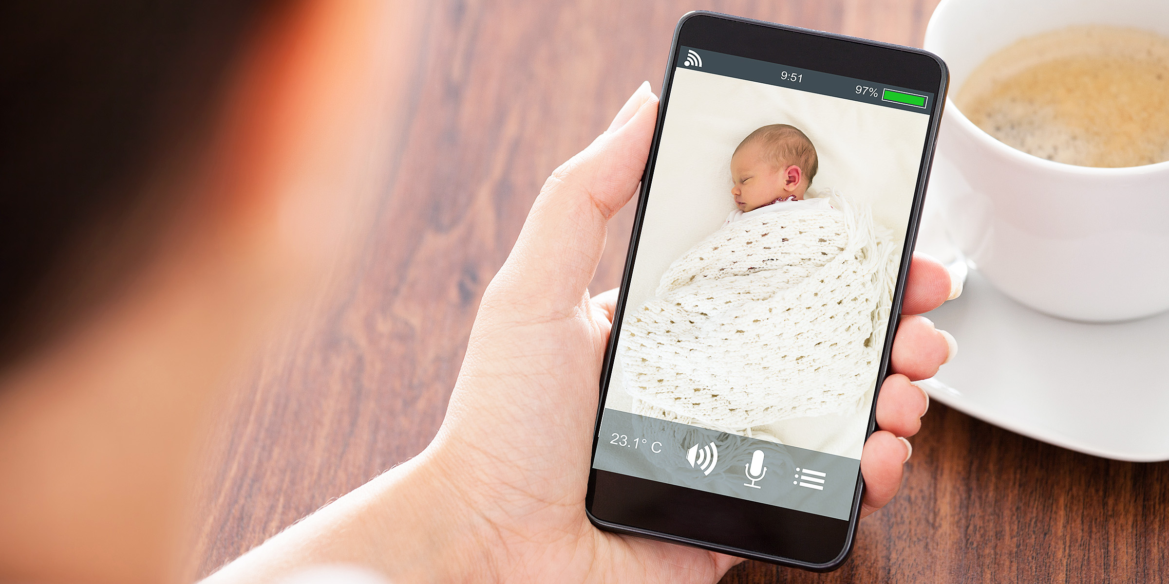Eine Person, die ein Baby auf dem Handy beim Schlafen beobachtet | Quelle: Shutterstock