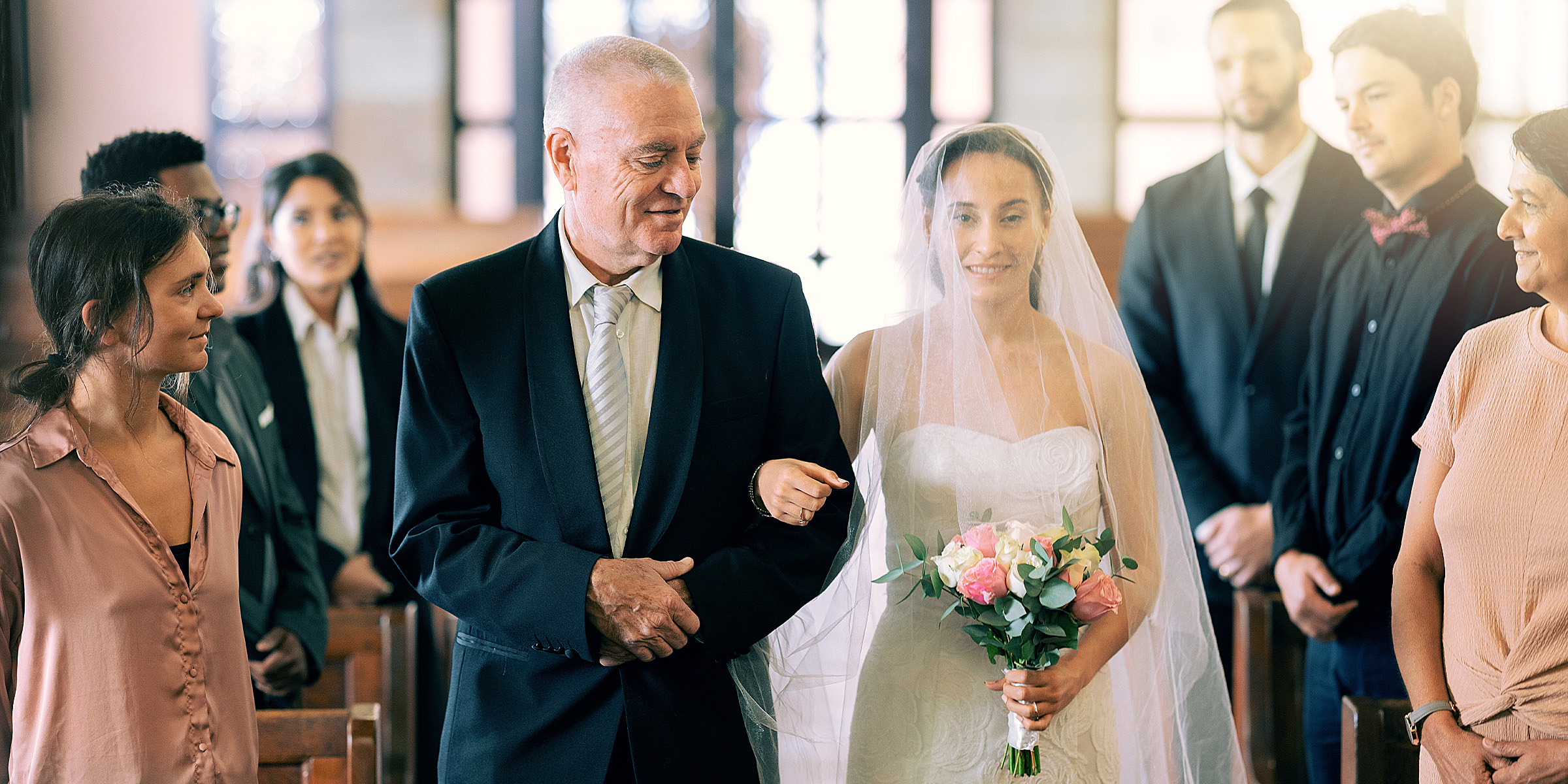 Eine Braut, die mit ihrem Vater zum Altar schreitet | Quelle: Shutterstock