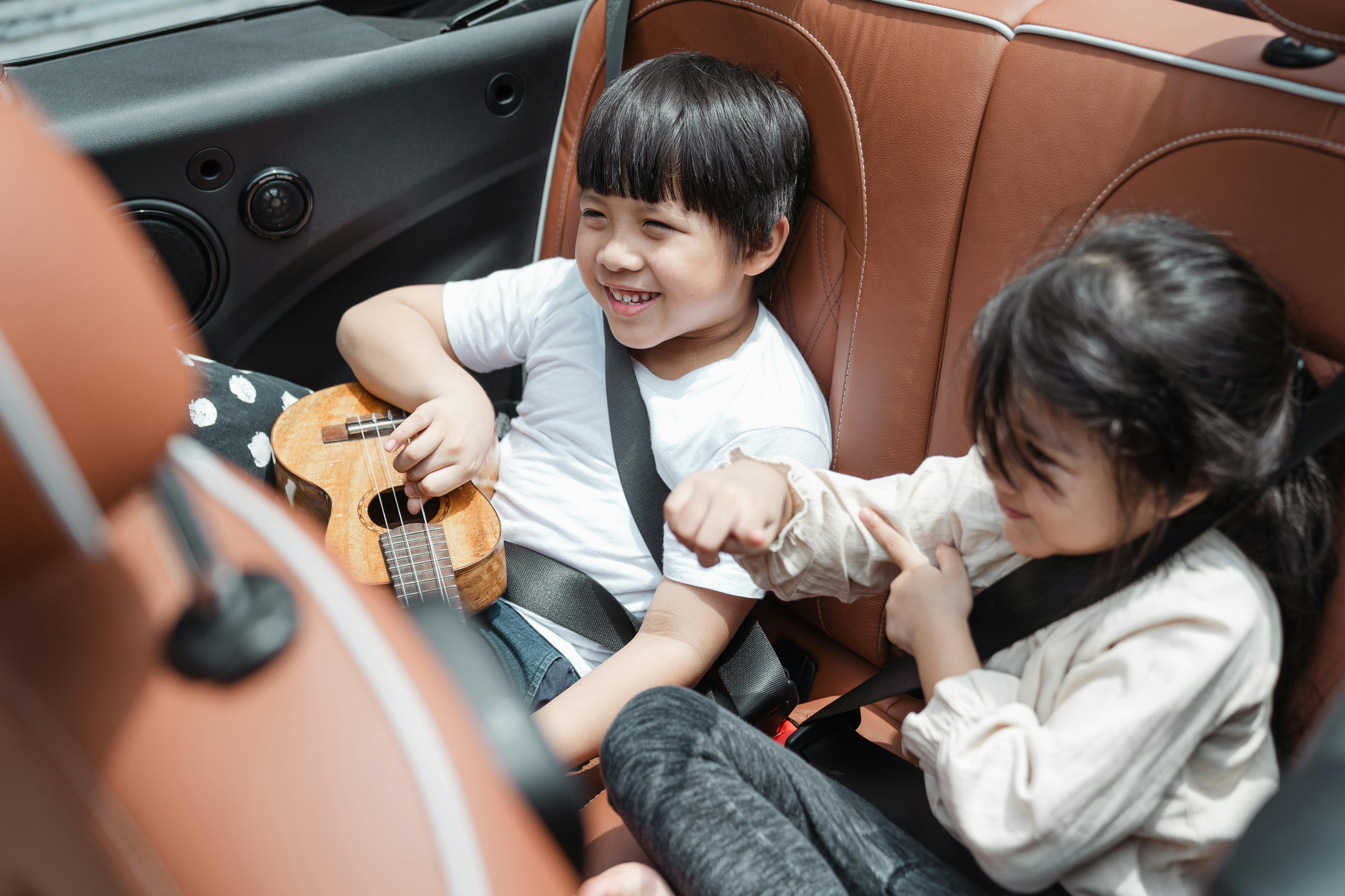 Aufgeregte Kinder auf dem Rücksitz eines Autos | Quelle: Pexels