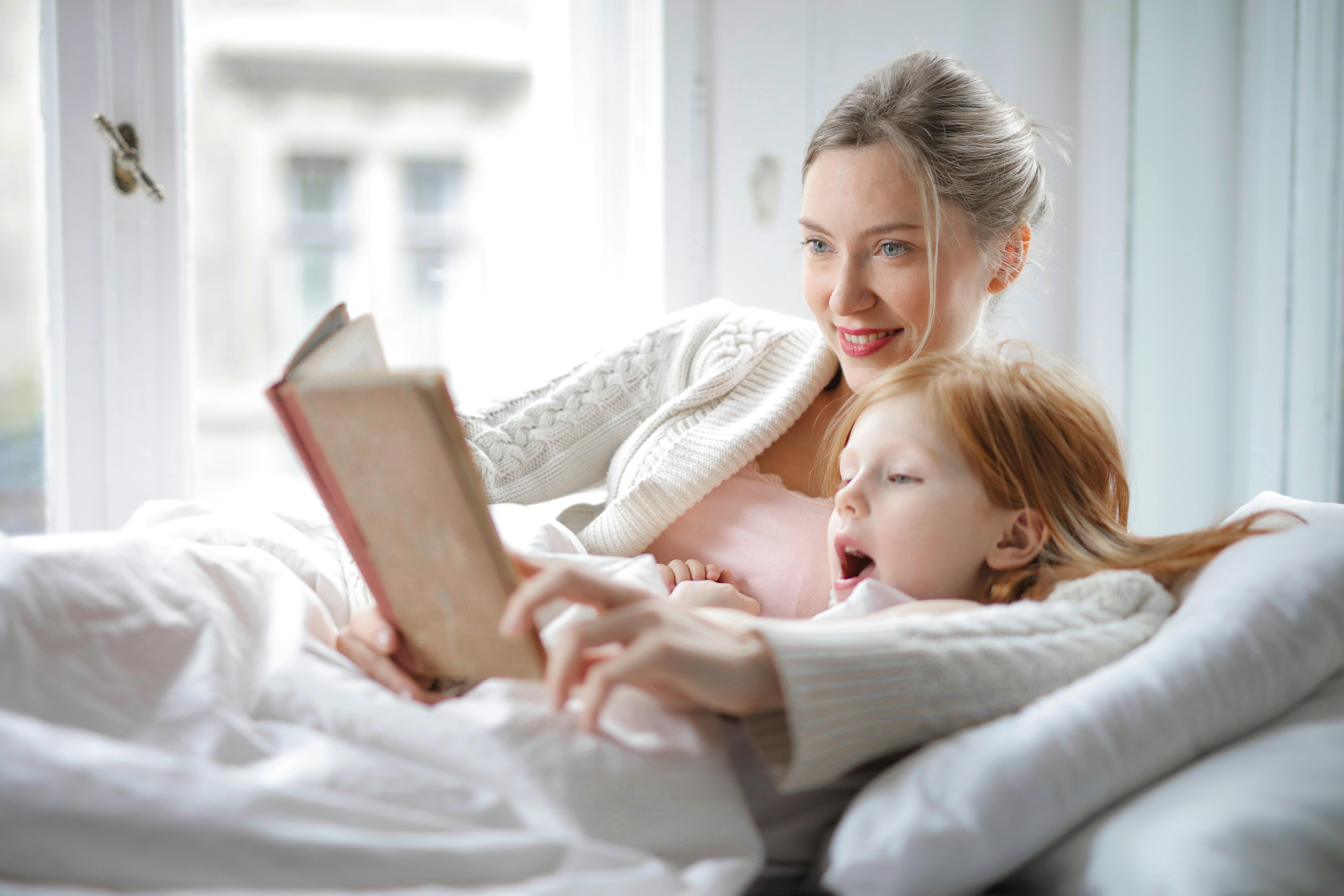 Eine Mutter, die ihre Tochter ins Bett bringt | Quelle: Pexels