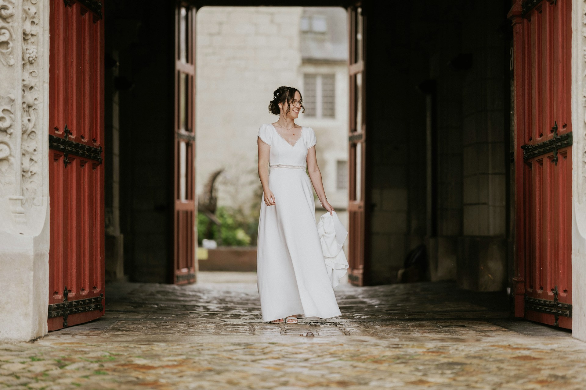 Eine Braut, die in der Nähe einer Tür steht und jemanden anlächelt | Quelle: Unsplash