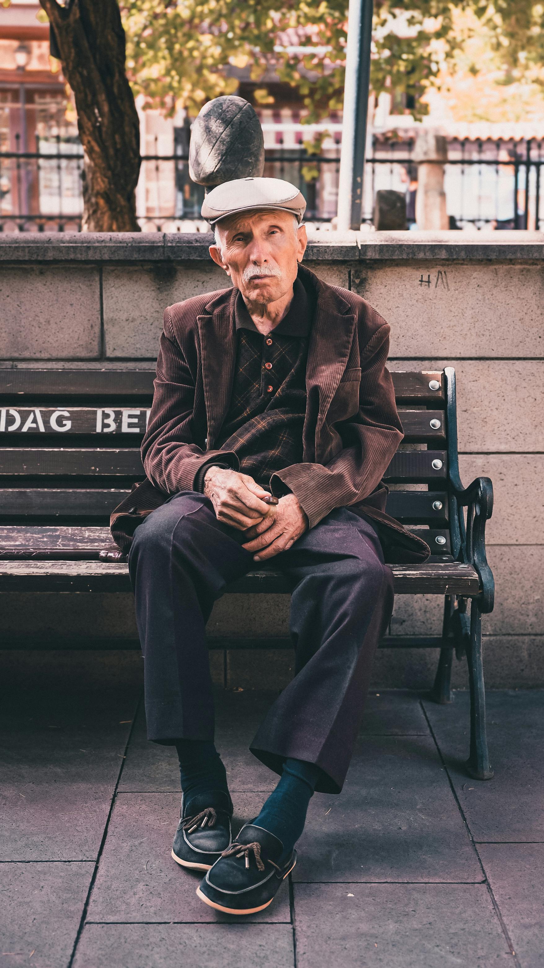 Ein älterer Mann sitzt auf einer Bank | Quelle: Pexels