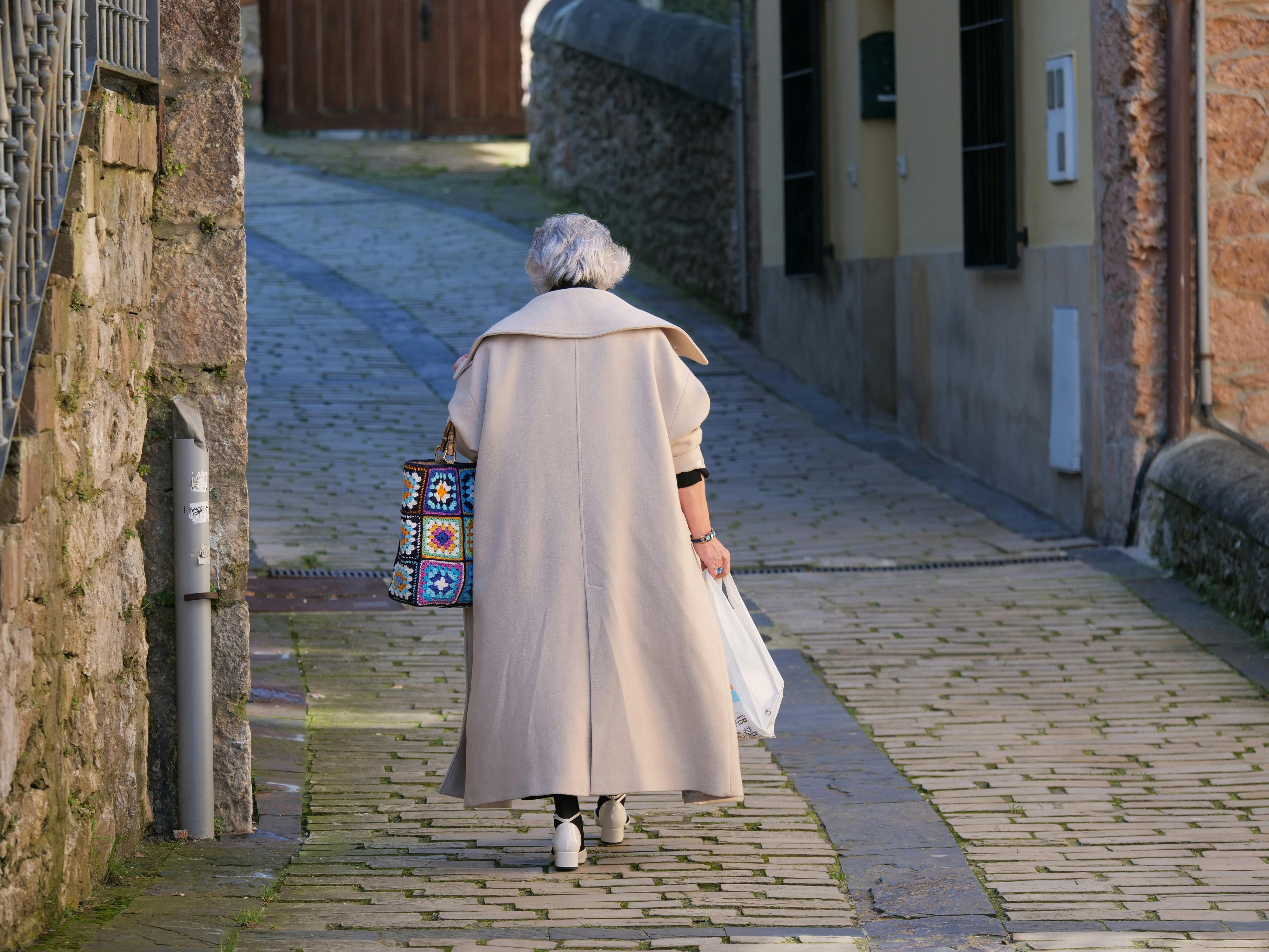 Eine alte Frau geht eine Straße entlang | Quelle: Pexels