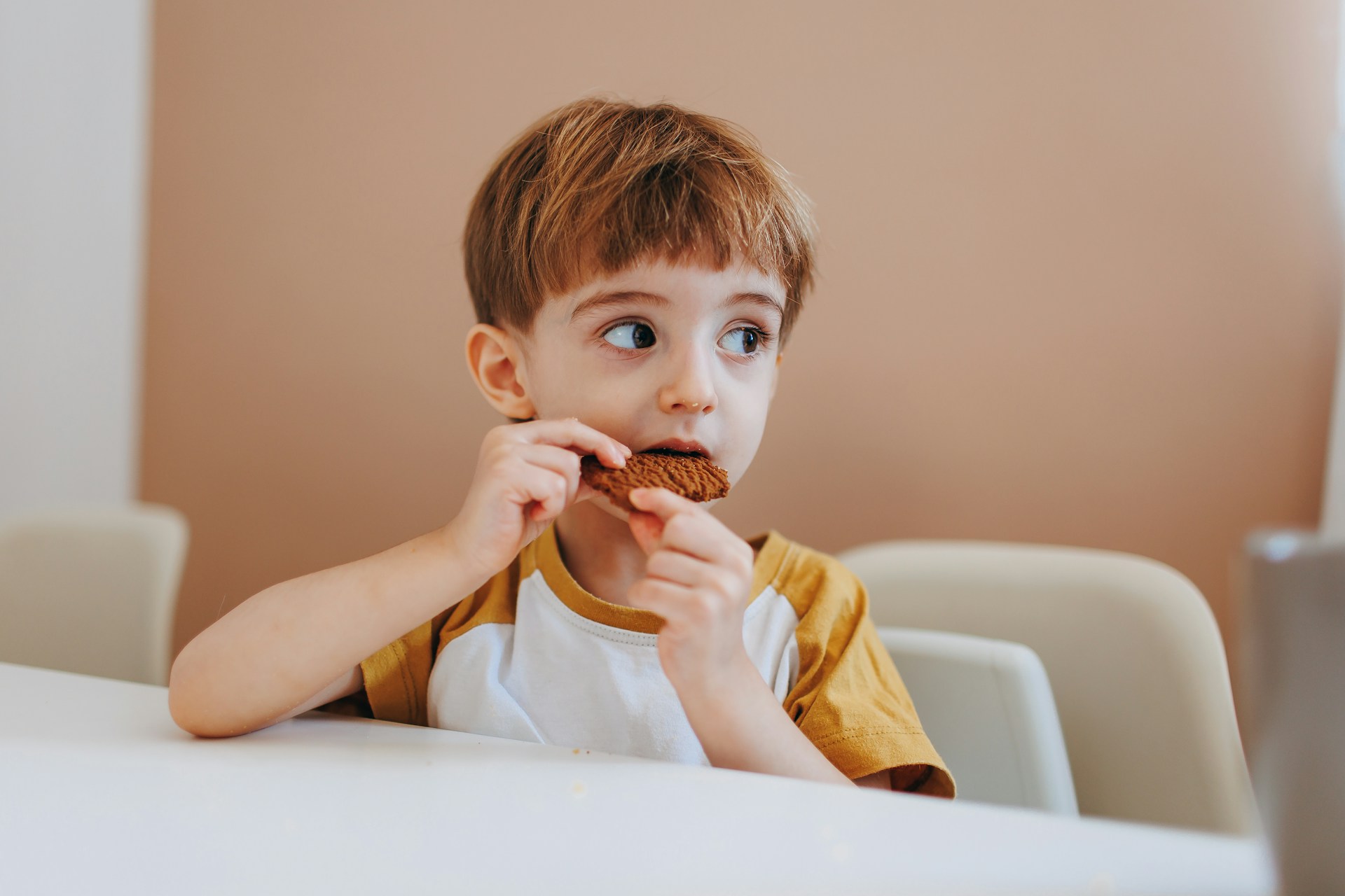 Ein kleiner Junge isst einen Snack | Quelle: Unsplash