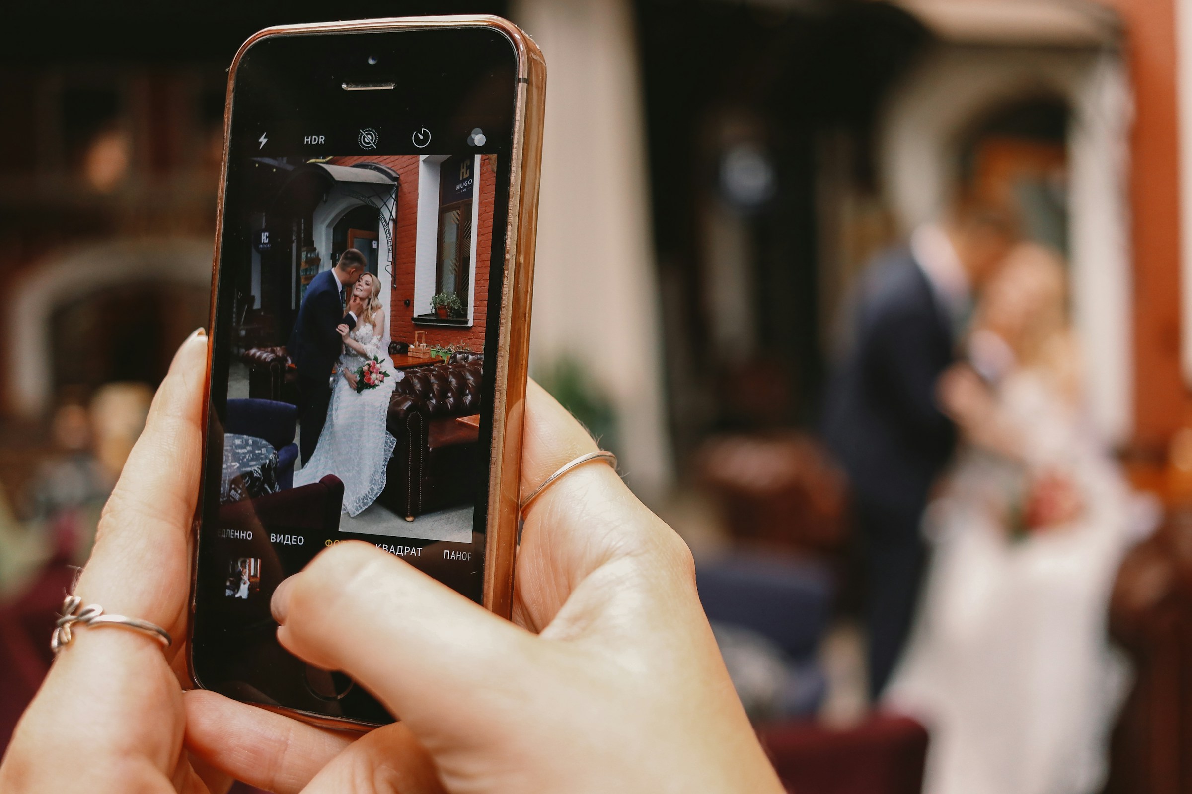 Eine Person, die ein Foto von Braut und Bräutigam auf ihrem Handy anklickt | Quelle: Unsplash