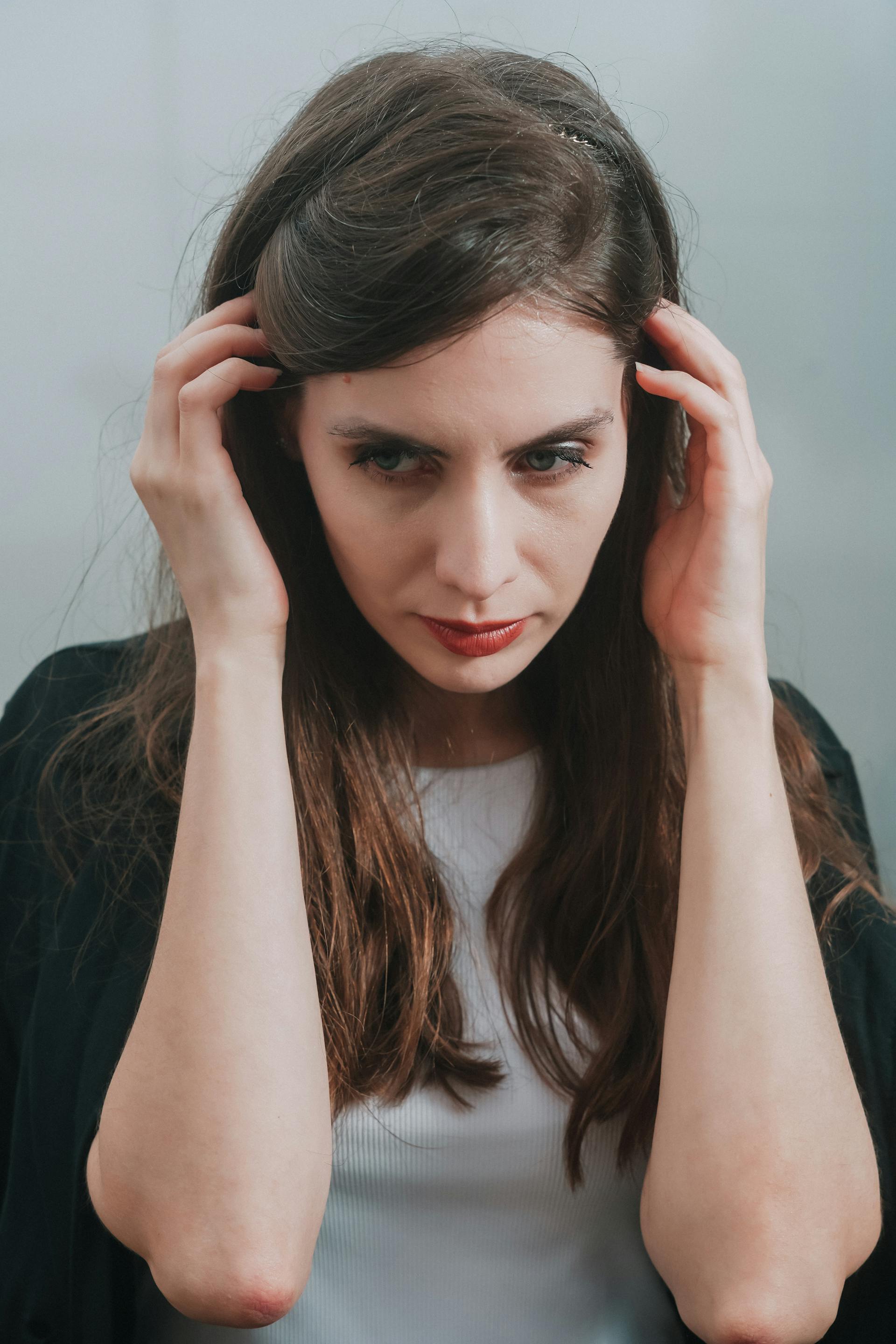 Eine Frau mit dem Kopf in ihren Händen | Quelle: Pexels