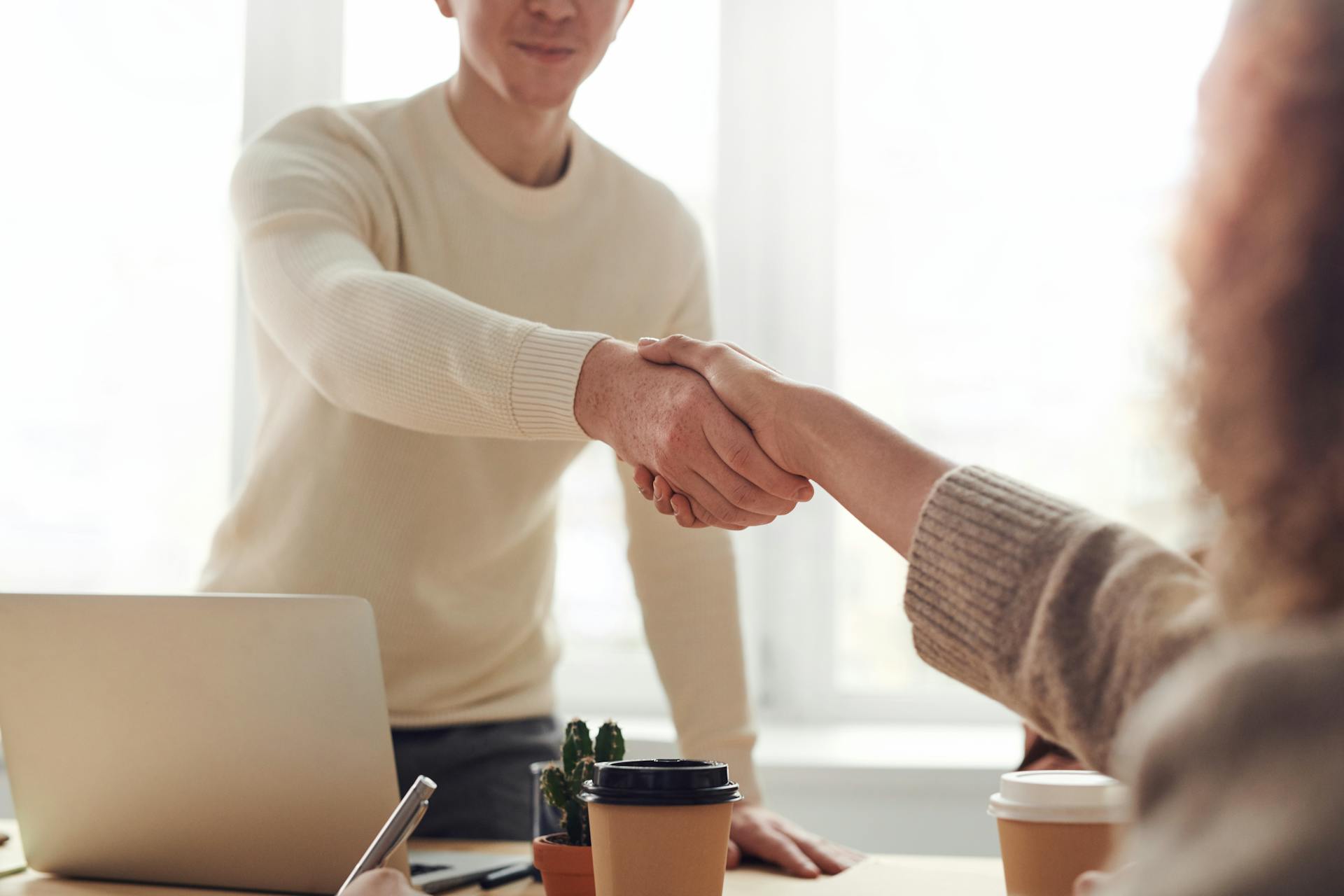 Eine Frau schüttelt einem Mann in einem Büro die Hand | Quelle: Pexels