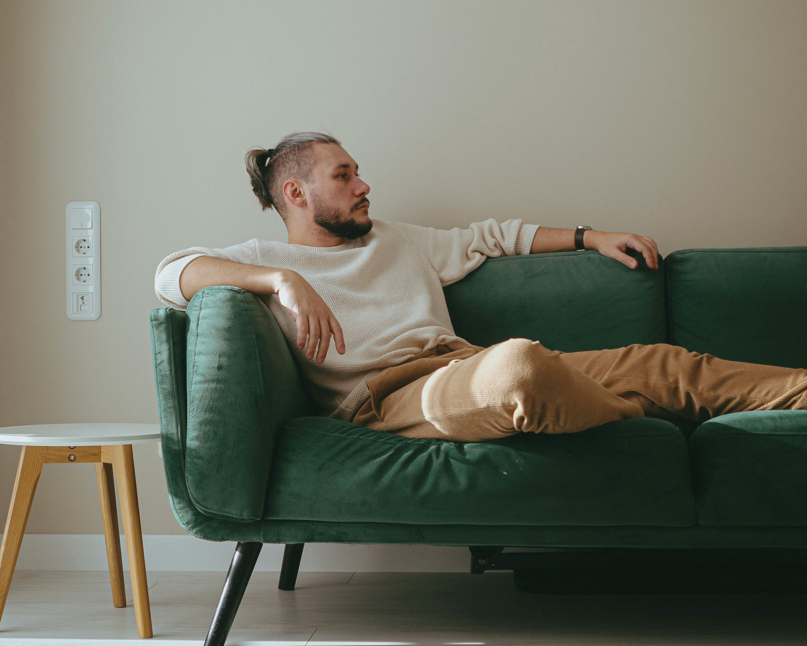 Ein Mann sitzt auf einer Couch | Quelle: Unsplash