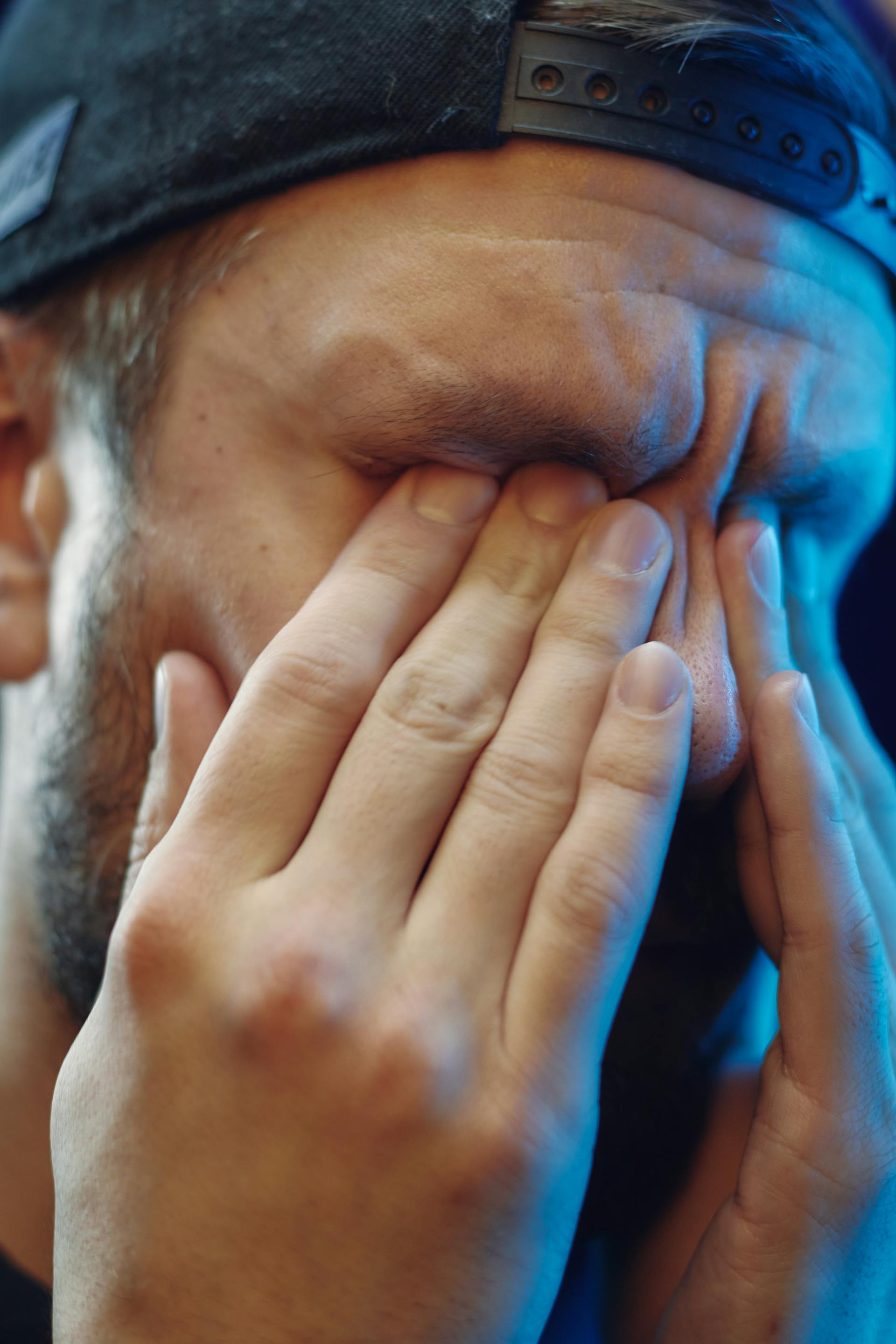 Ein verzweifelter Mann, der sein Gesicht mit seinen Händen bedeckt | Quelle: Pexels