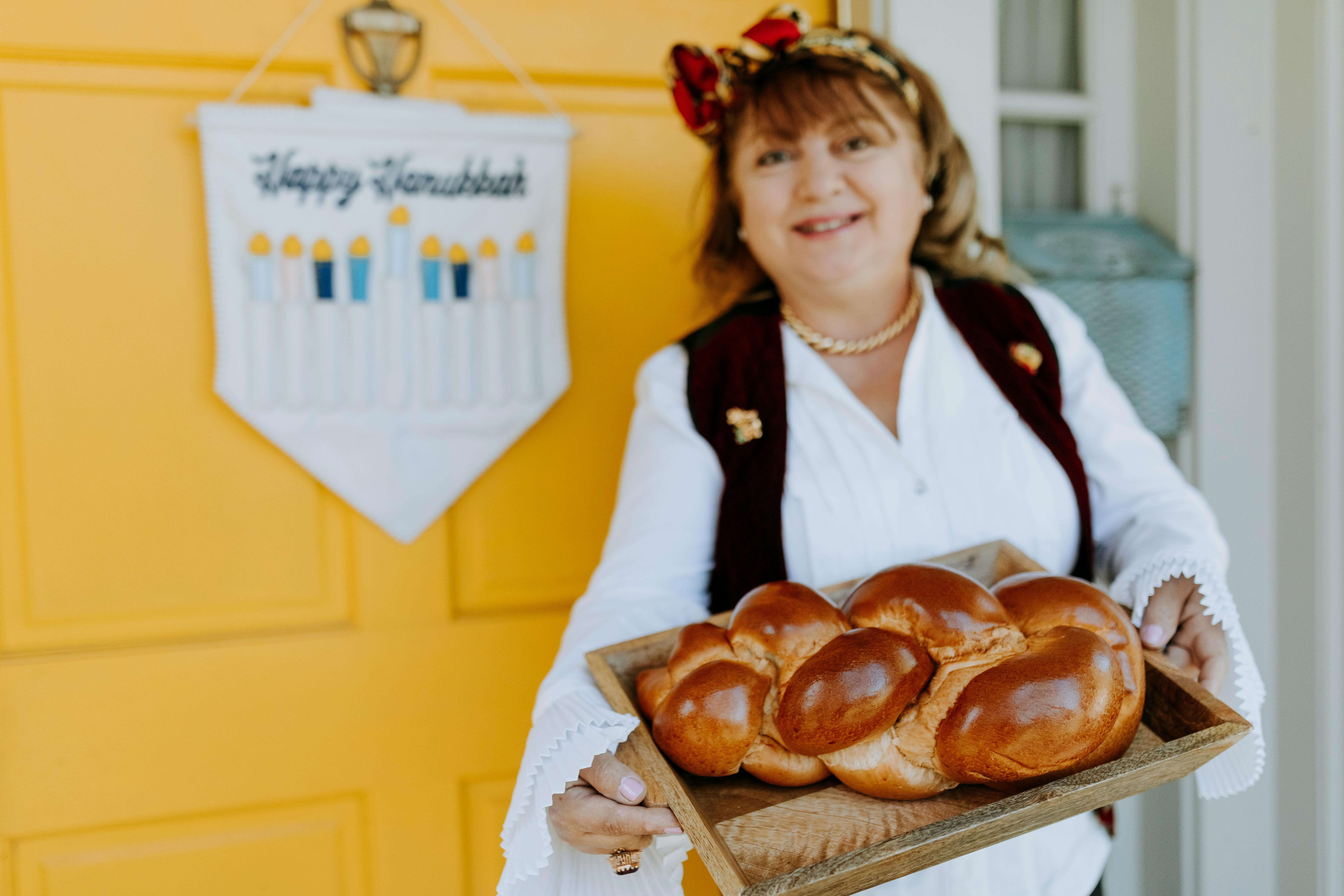Eine Frau hält ein Tablett mit Brot | Quelle: Pexels