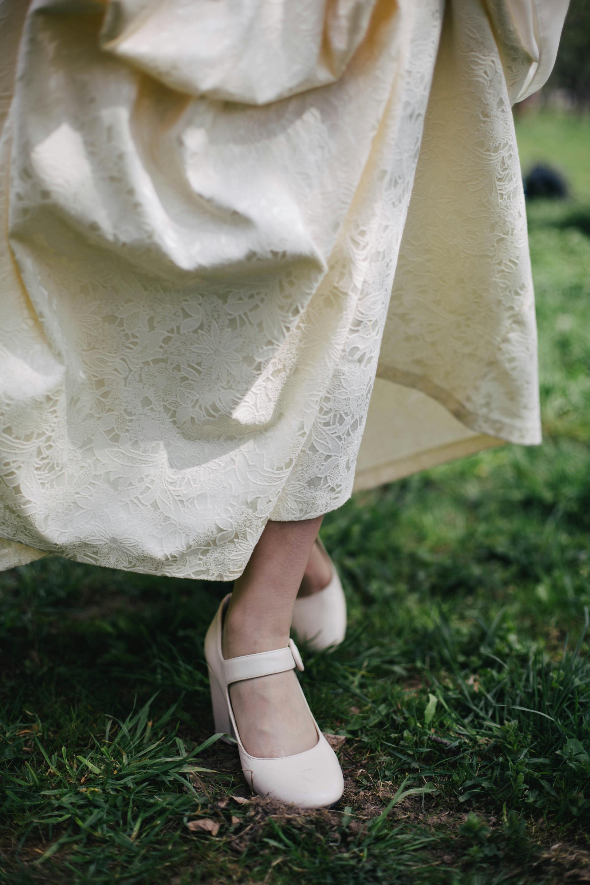 Eine Person in einem cremefarbenen Kleid läuft durch Gras | Quelle: Pexels